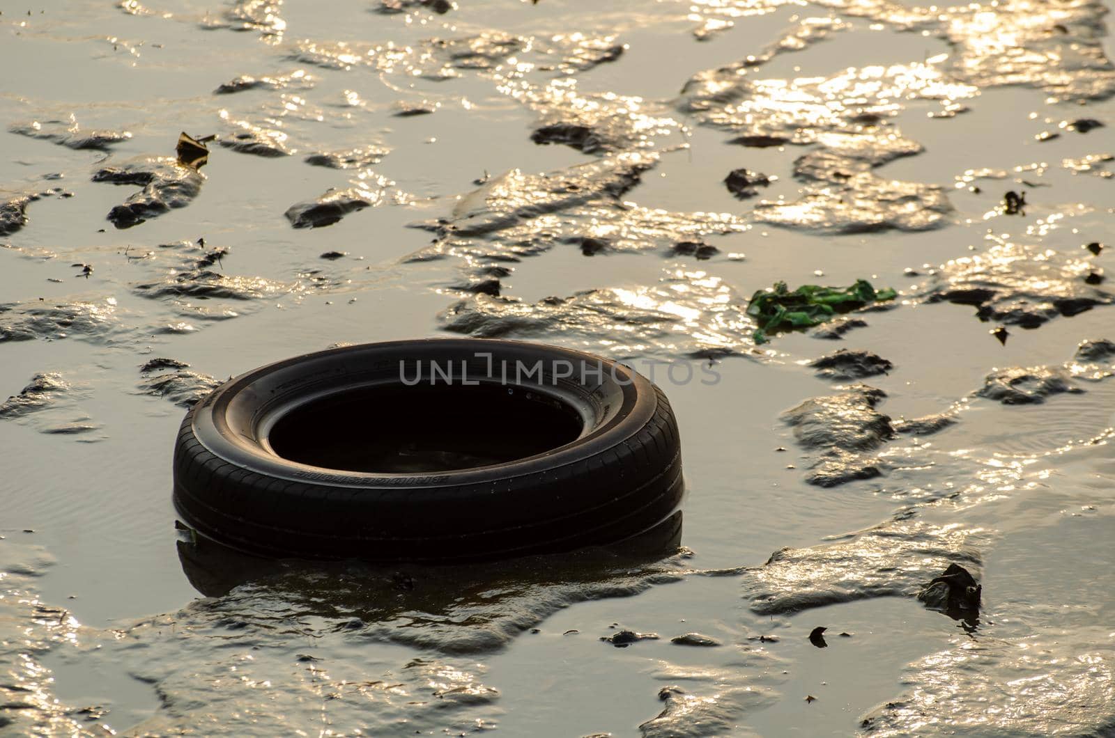 Batu Maung, Penang/Malaysia - Dec 28 2019: Car tire and other rubbish at sea in sunlight morning.