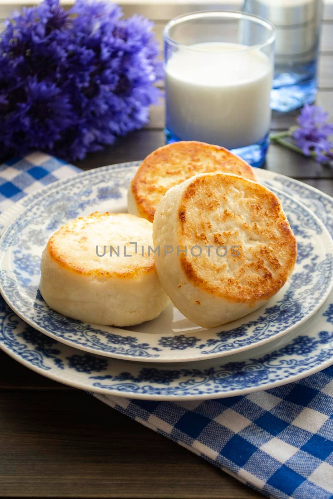 Cottage cheese pancakes with blue cornflower, breakfast or lunch. Vertical image