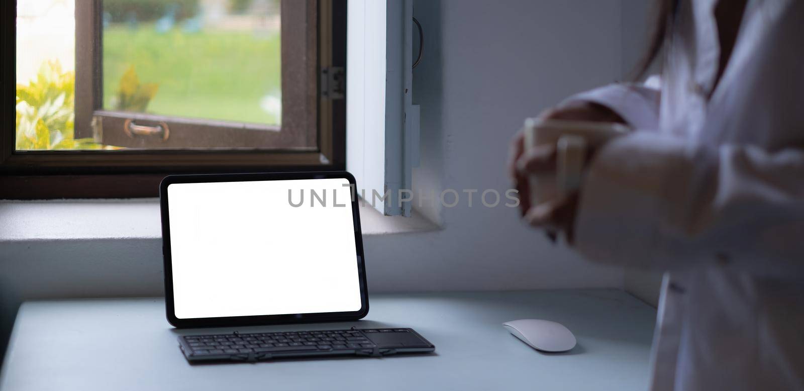 Mockup image of a black tablet with white blank screen on wooden desk. by itchaznong