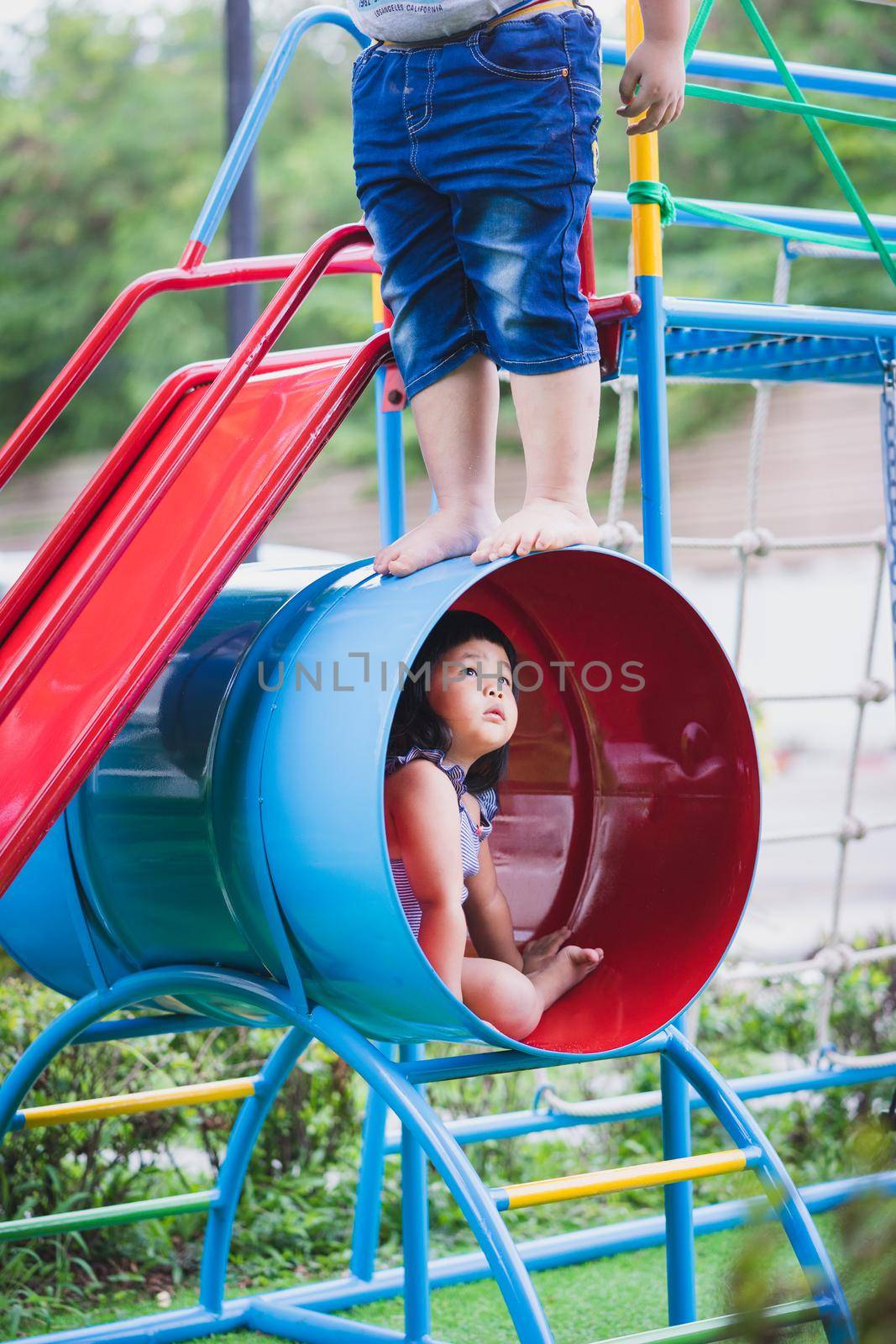 Asian little girl fear in a children playground by domonite