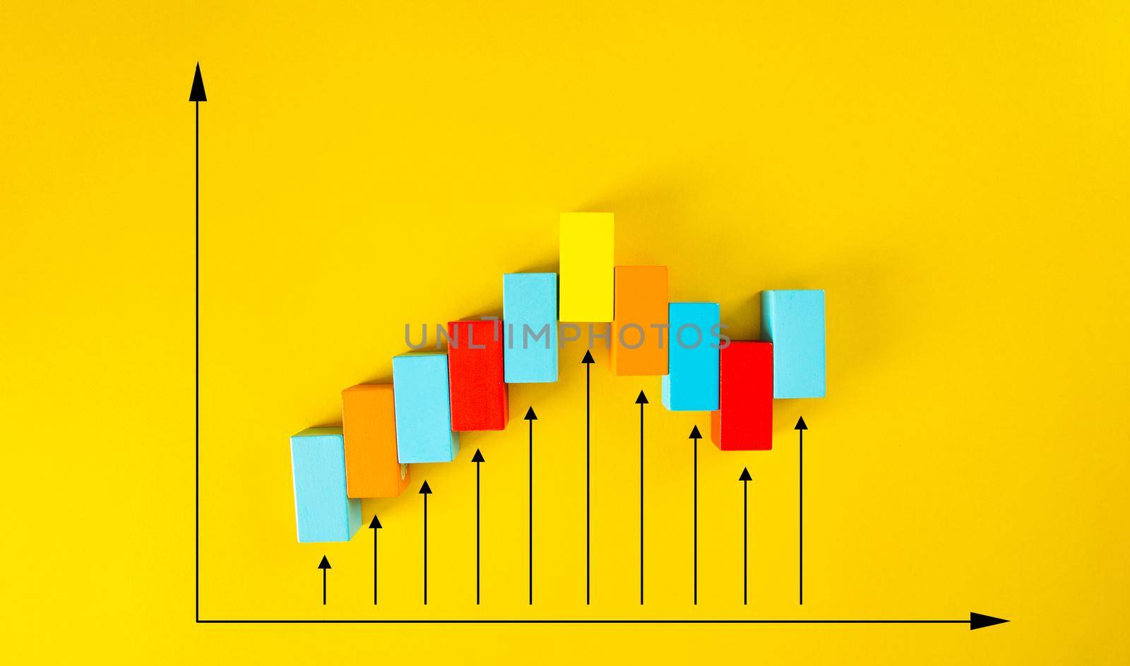 Wooden blocks arranged in an increasing graph on yellow background.  by tehcheesiong