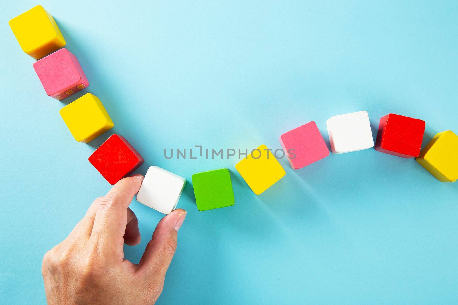 Hand arranging colorful wooden block. Business and Personal Development Concept.