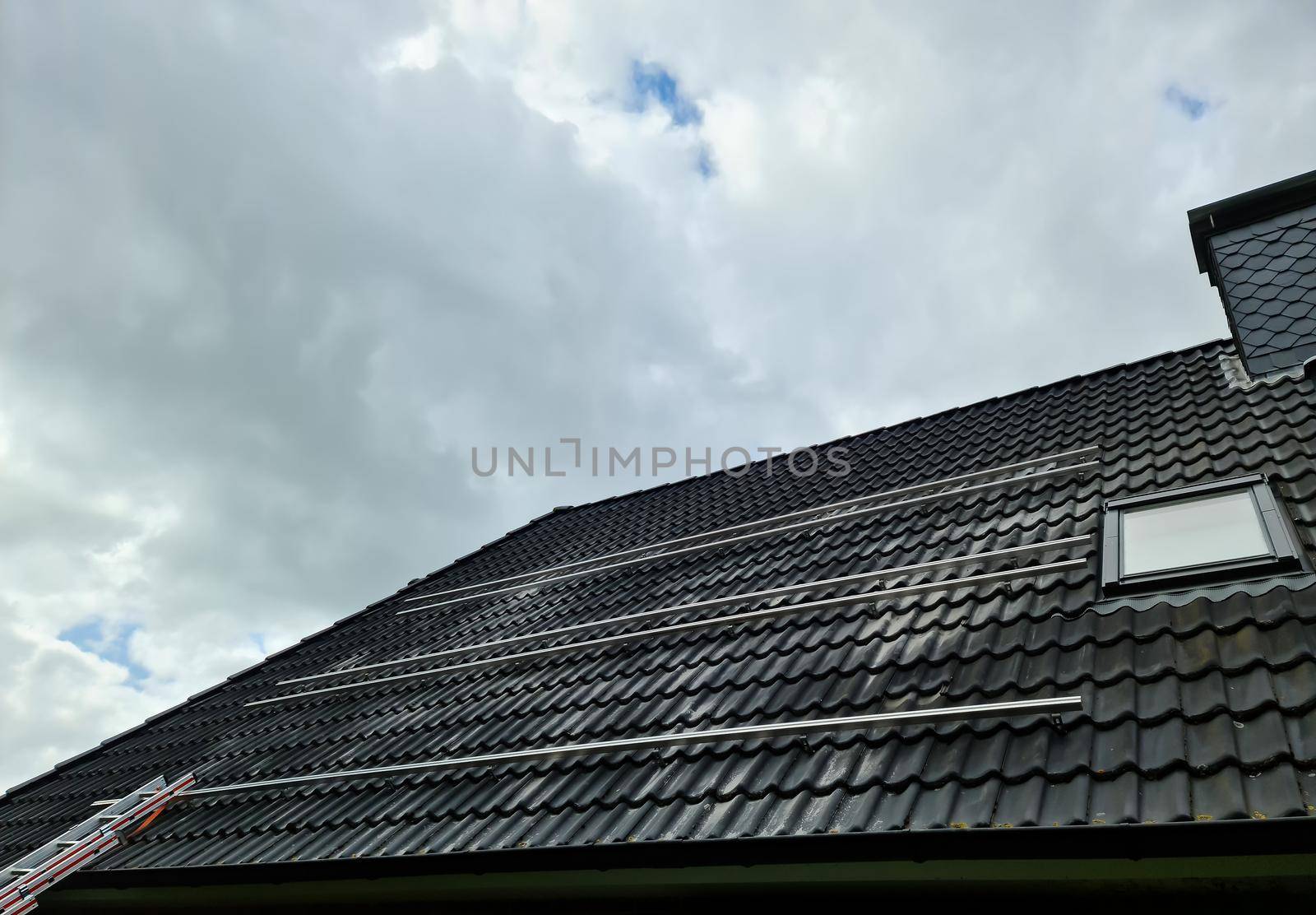 View at the roof tiles and a ladder of a residential house during roof repair