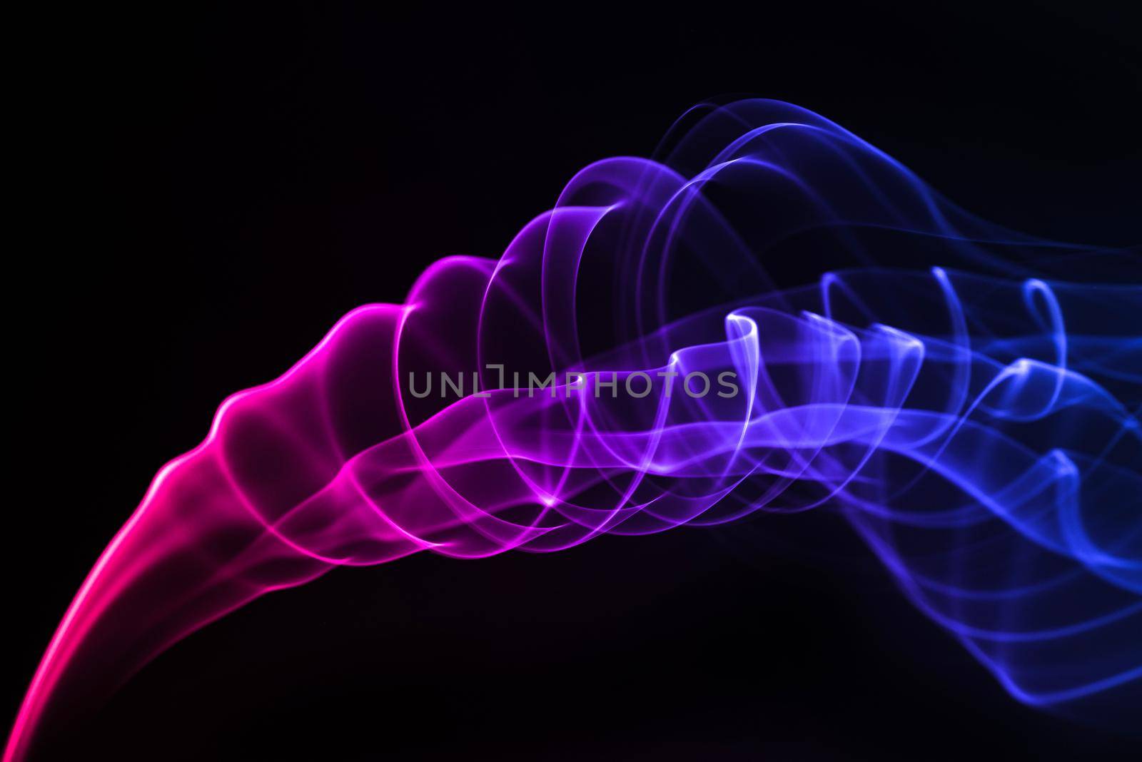 Blue with purple smoke isolated on black background. by thanumporn