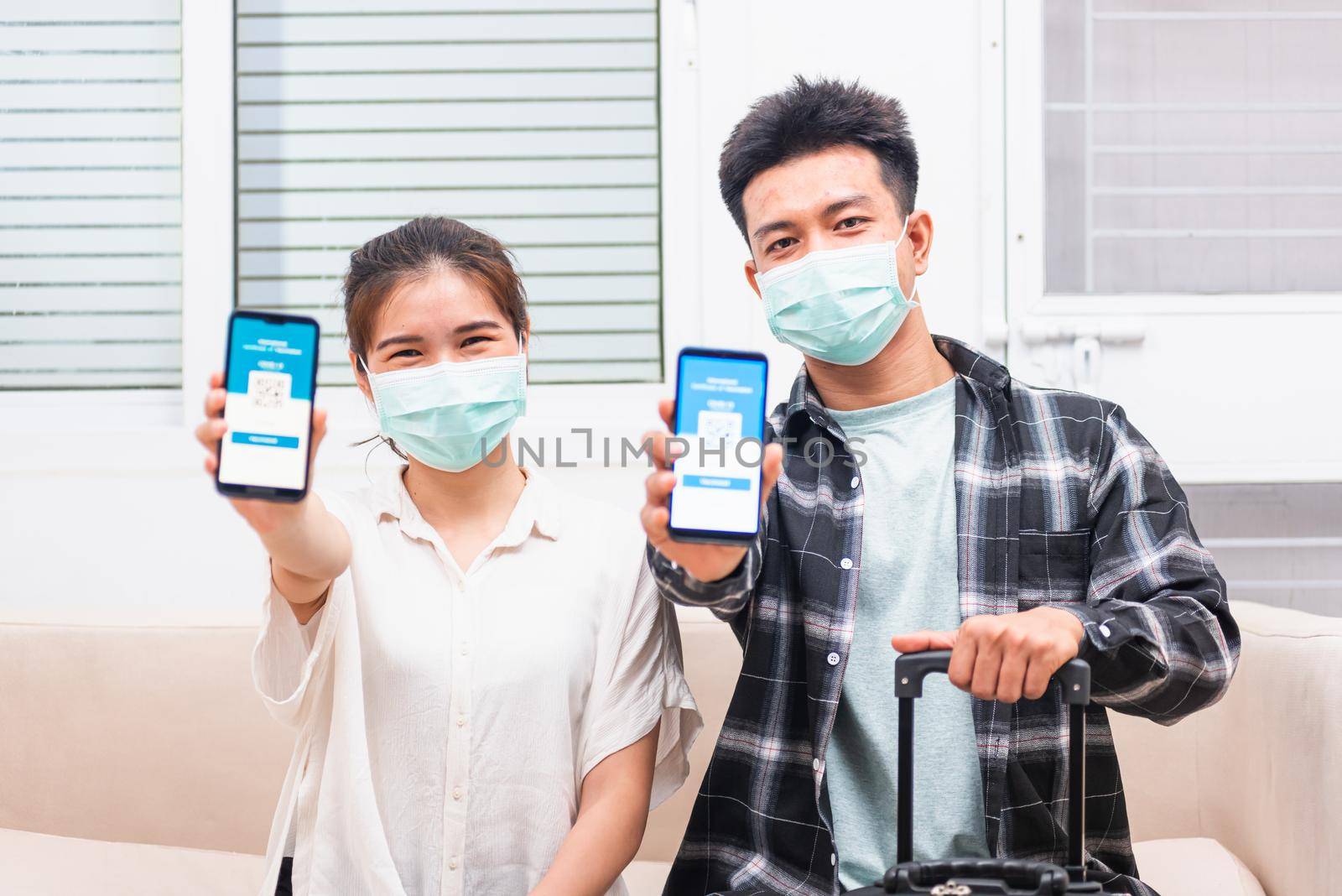 couple woman and man ready to travel showing digital vaccine health passport certificate app in smartphone by Sorapop