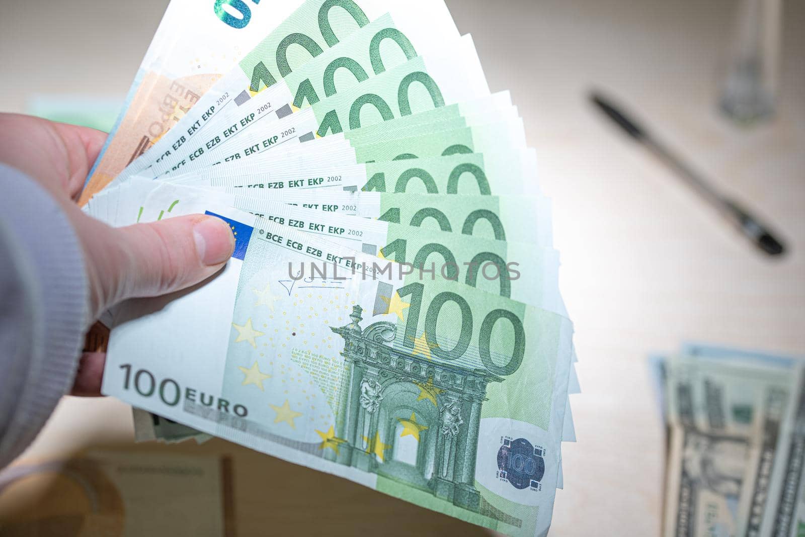 Heap of green houndred euro banknotes in the hand
