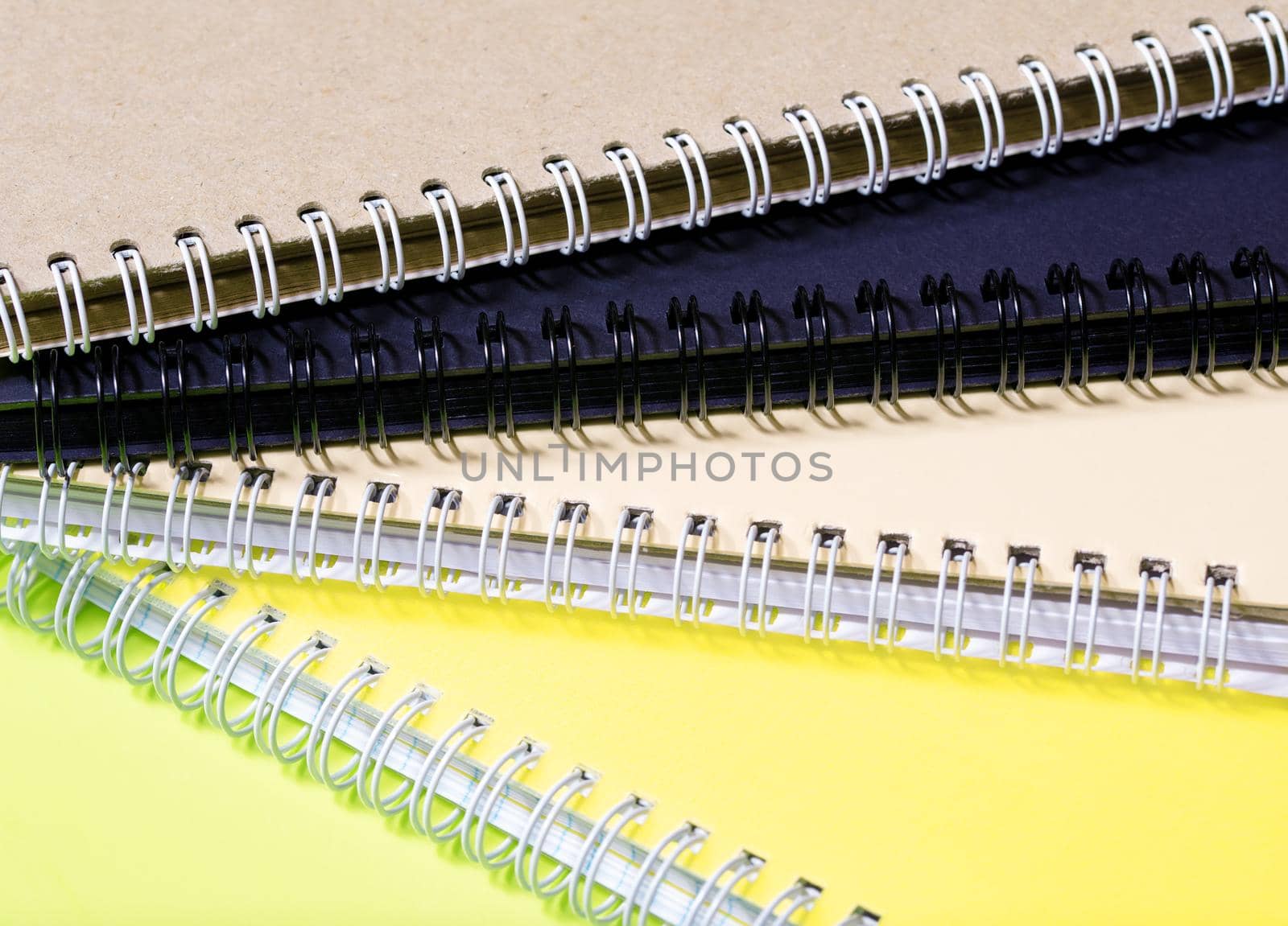 Stack of colourful notebooks with spiral edge by Estival