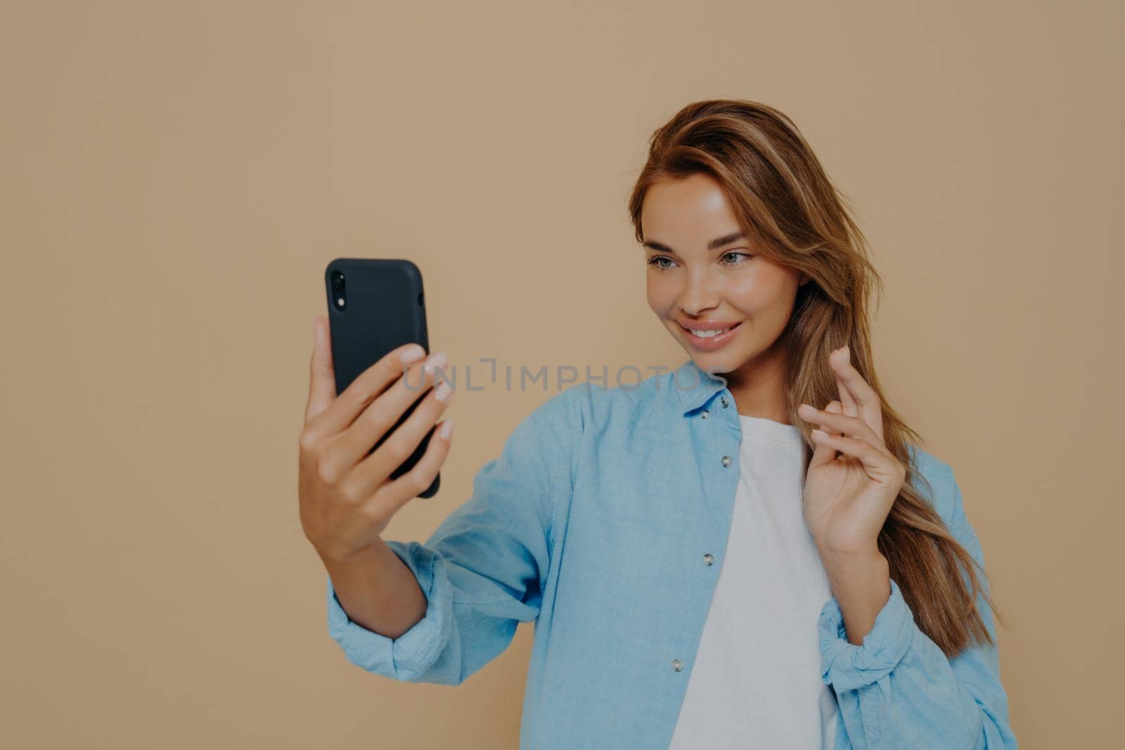 Pretty young woman makes selfie with smart phone by vkstock