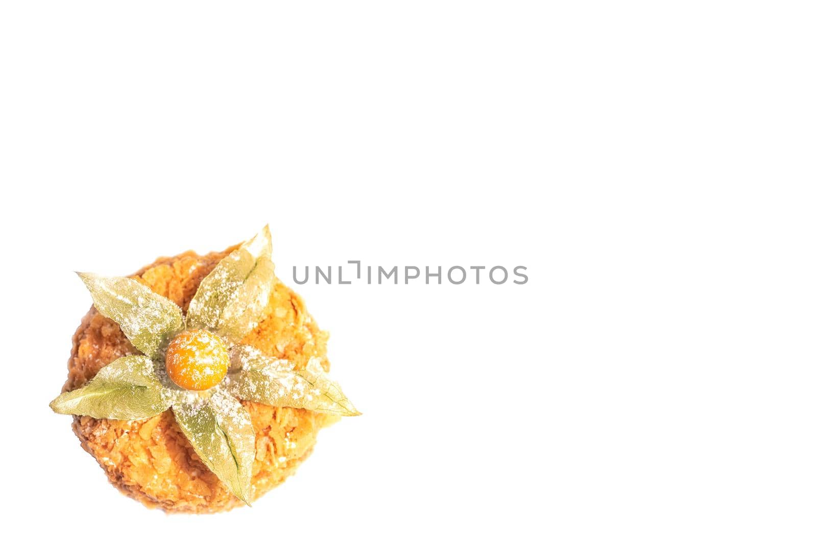 Honey cream cake with fisalis at the top isolated on a white background
