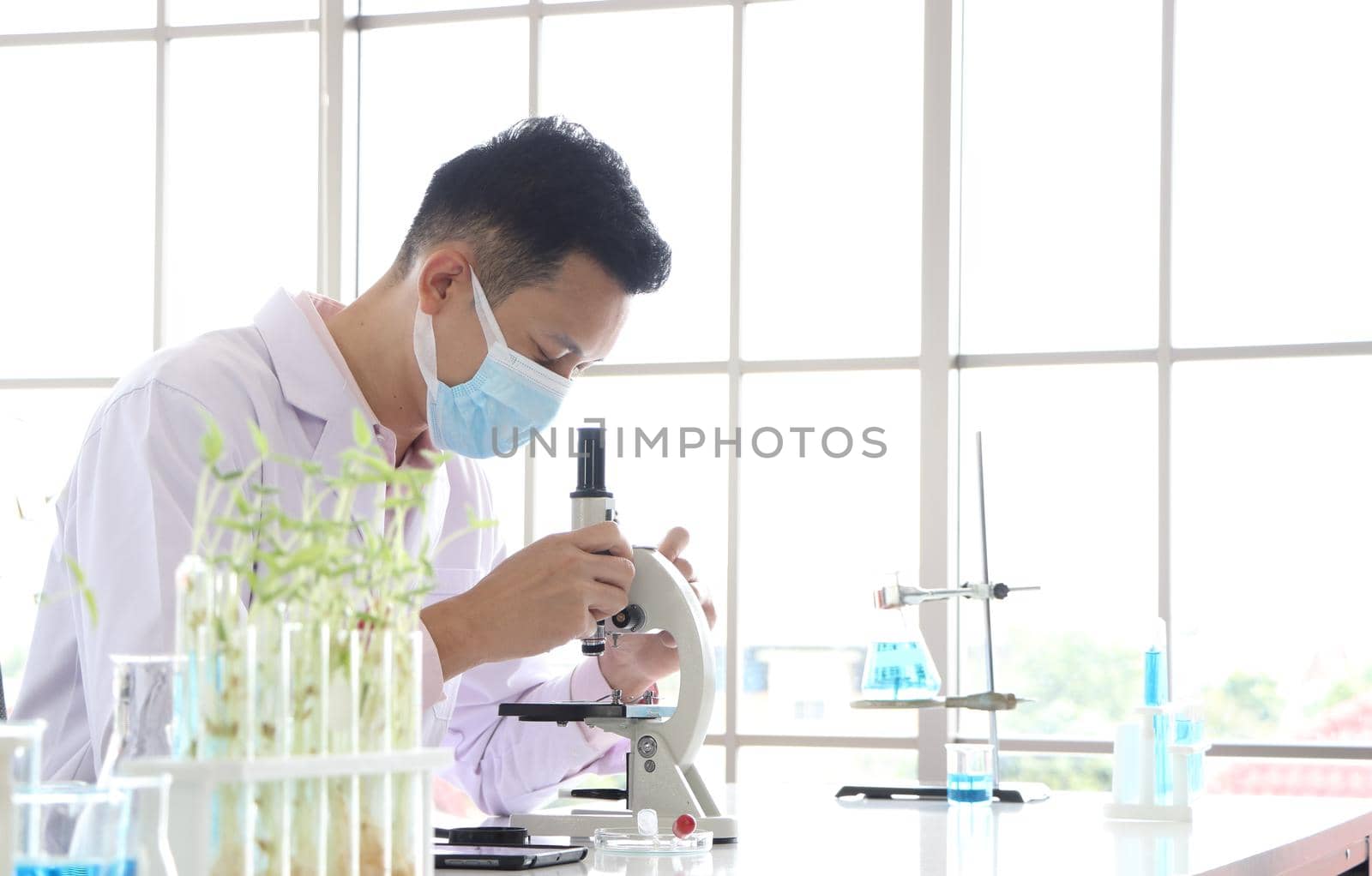 Asian scientists or chemists use a microscope. In science experiment Medical pharmaceutical research concept DNA structure, innovation and technology