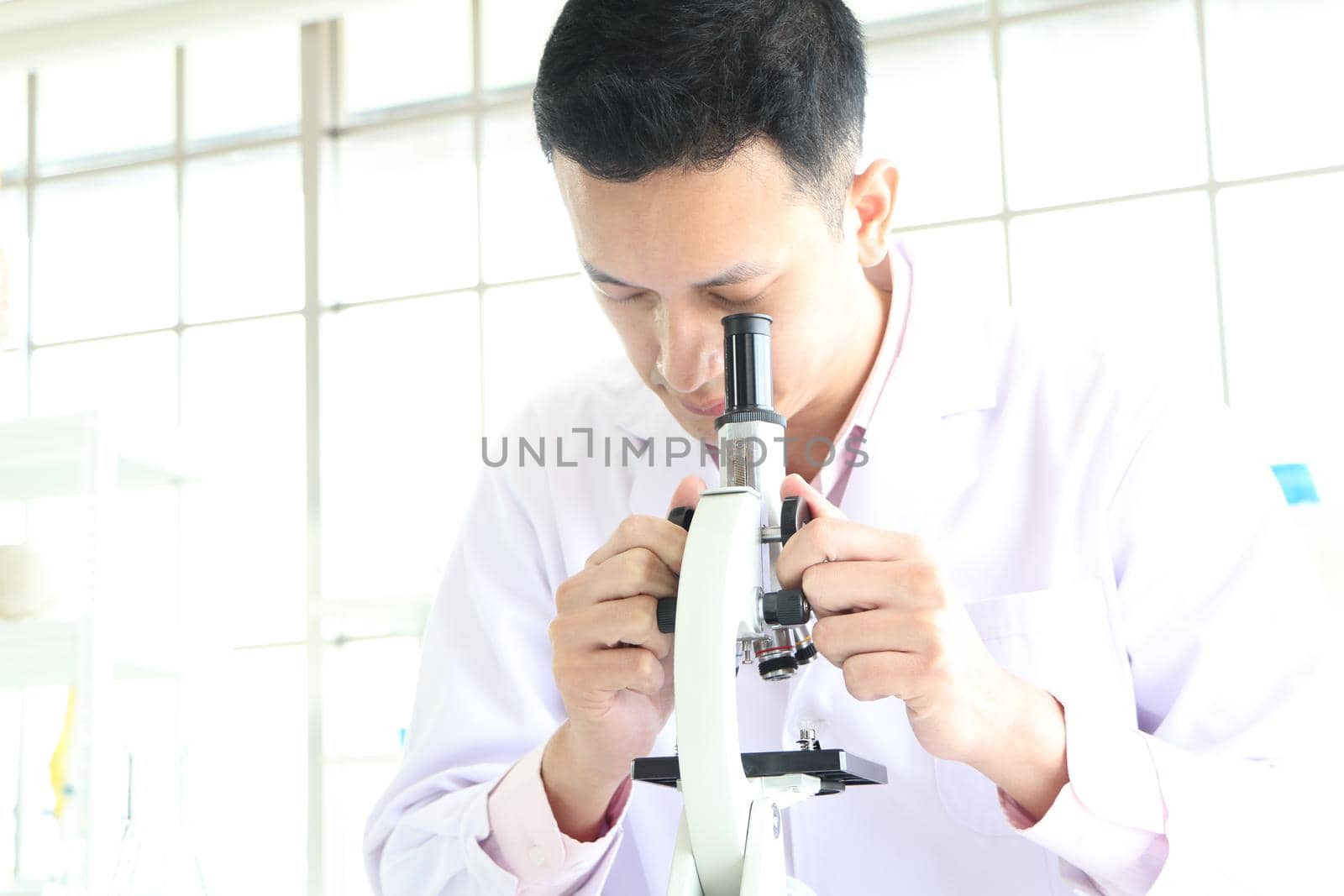 Asian scientists or chemists use a microscope. In science experiment Medical pharmaceutical research concept DNA structure, innovation and technology