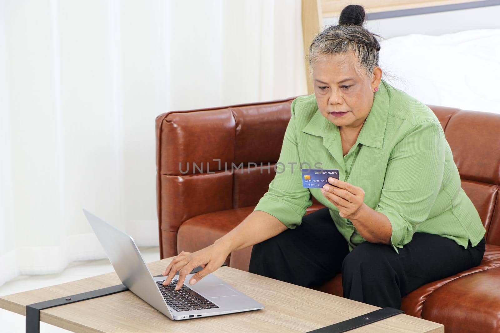 Retirement women in Asia use laptops and credit cards by atitaph