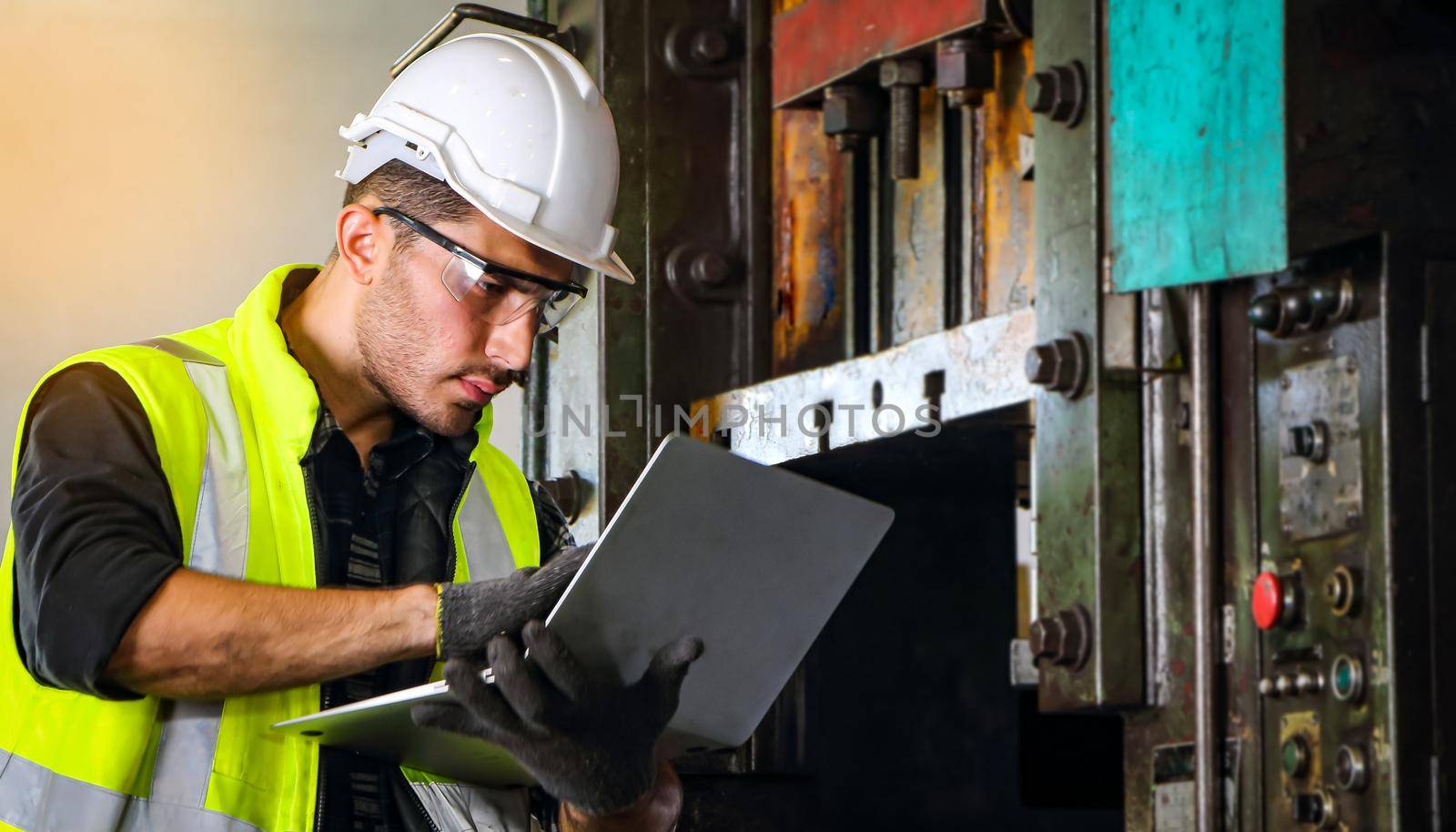 A professional male engineer wearing a uniform and glasses uses a laptop to find maintenance information. And installation of machines in industrial plants With confidence Concept of engineering