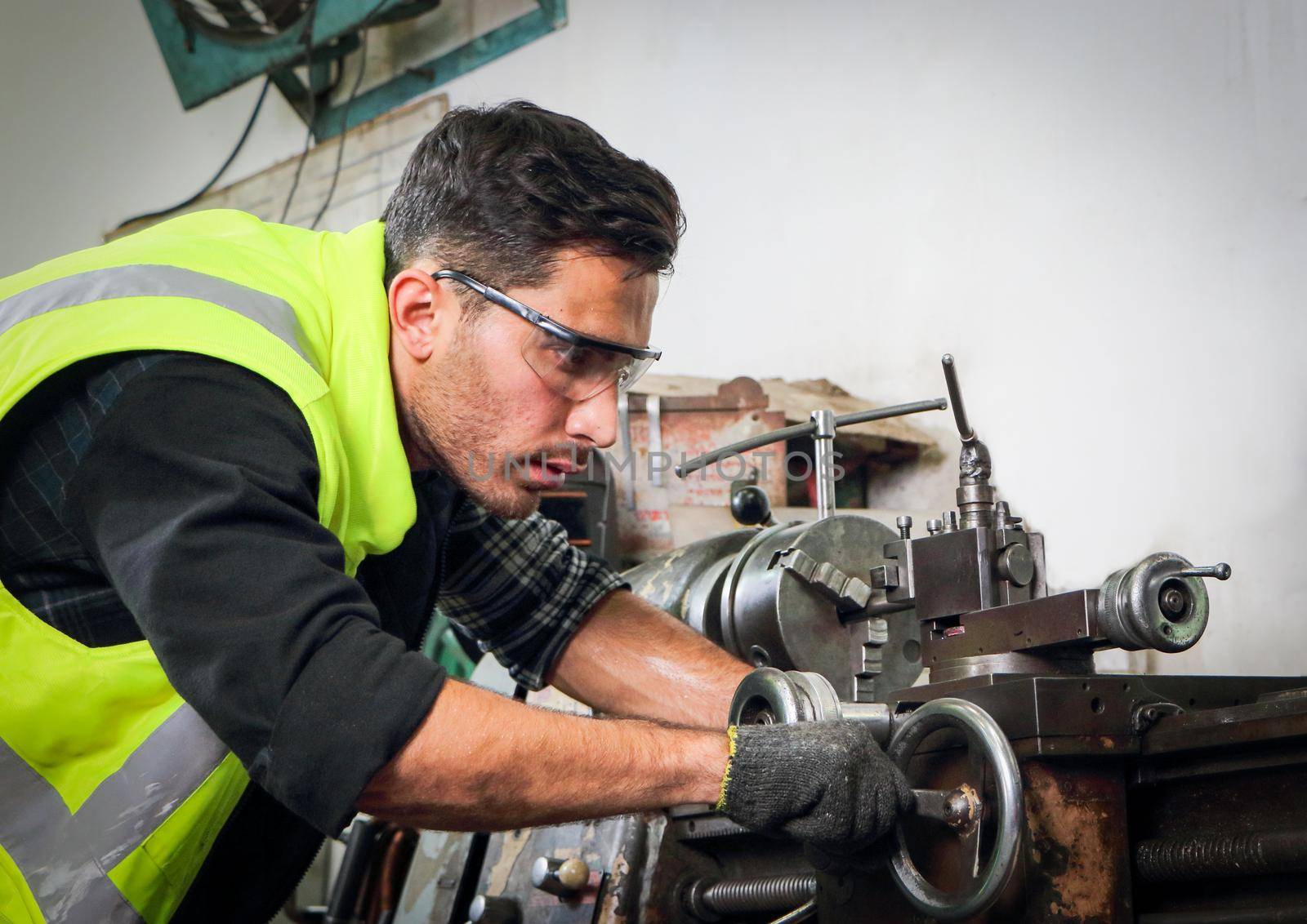 Engineers with professional skills Working on a lathe cutting machine. Concept, workers are producing machine parts. For use in the maintenance of metal stamping machines in industrial plants.