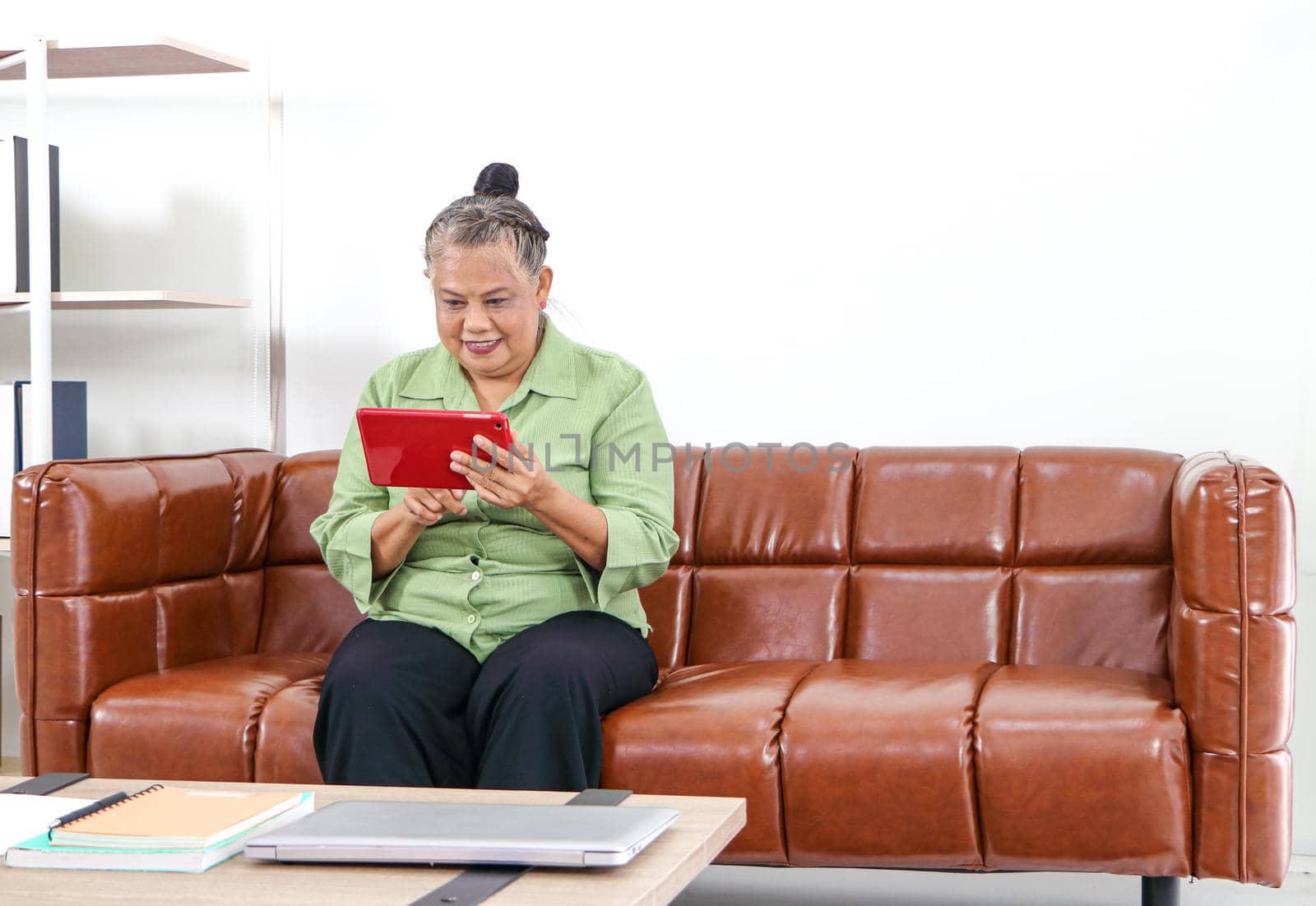 Asian women Retirement Use a smartphone in the living room  by atitaph