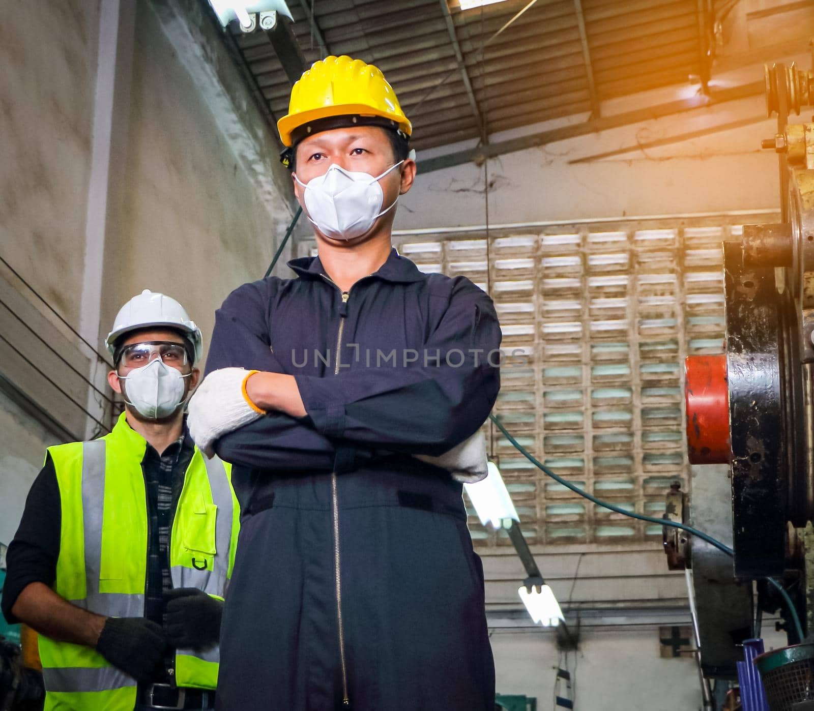 A male worker wearing a mask that protects against COVID 19, the concept of preventing the spread of COVID, or COVID while working. Maintenance and installation of industrial machinery