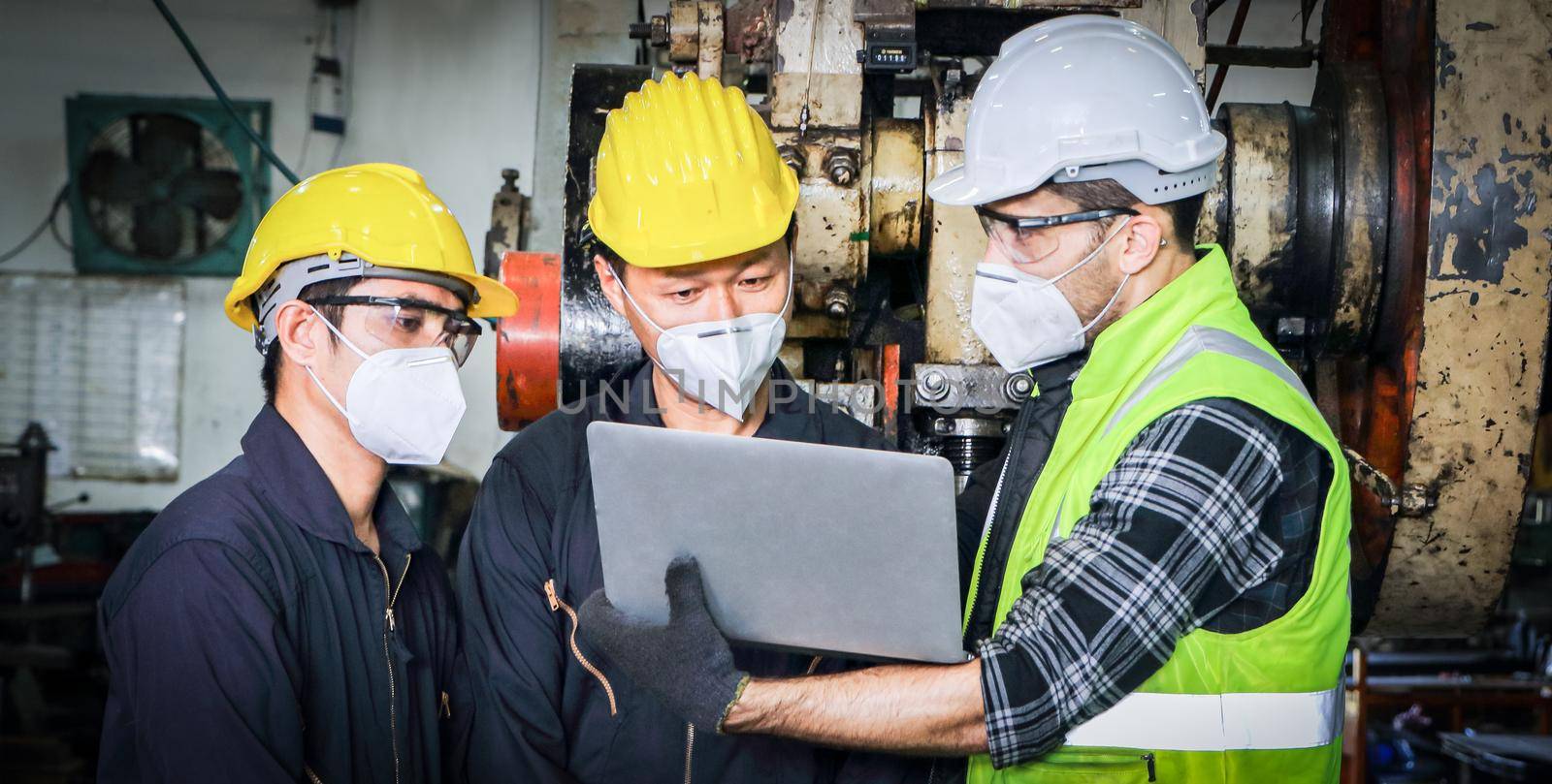 team of professional Asian male engineers, wearing uniforms and glasses, is using a labtop to research the maintenance and installation of the machines. In industrial plants with engineering concepts