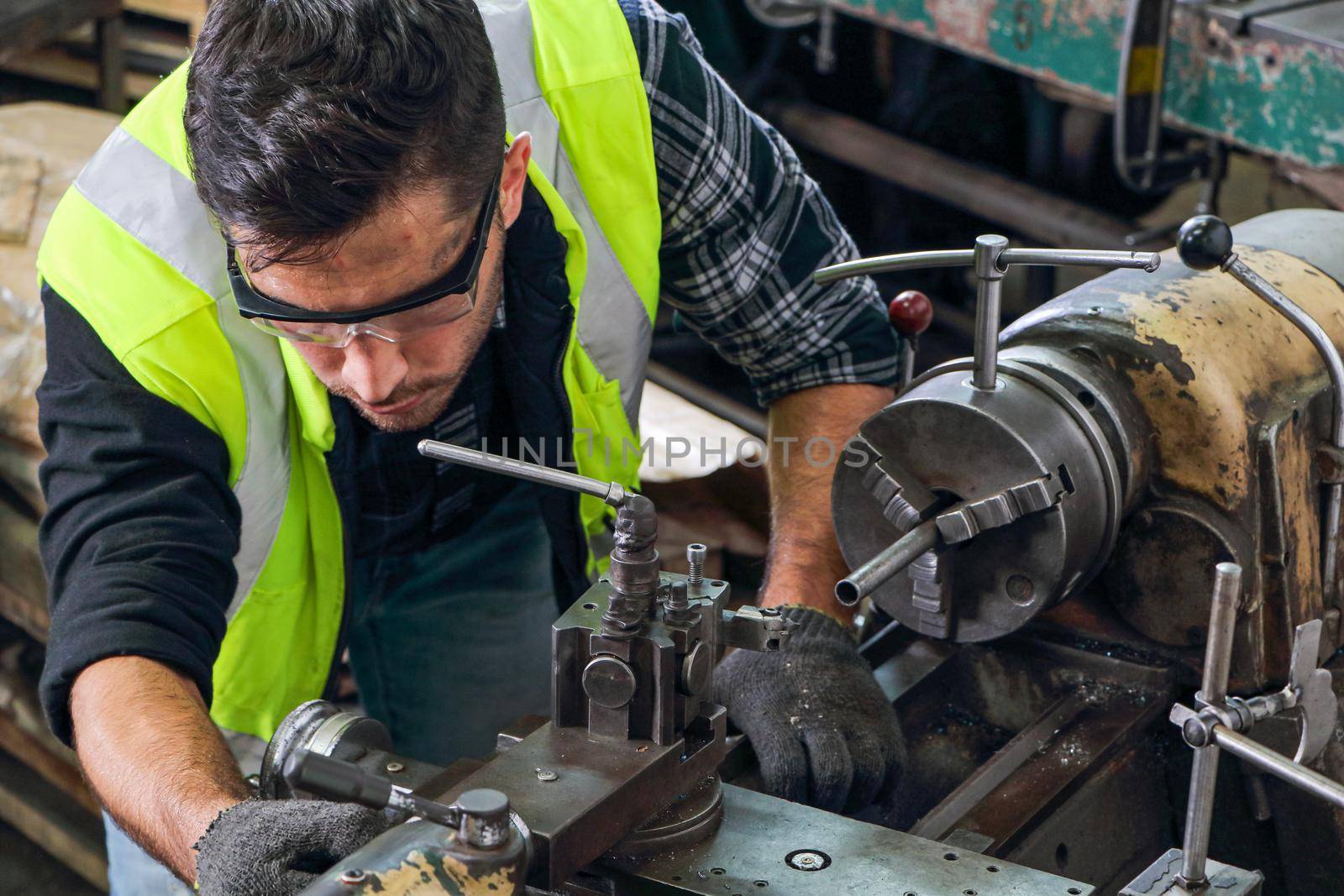 Engineers with professional skills Working on a lathe cutting machine. Concept, workers are producing machine parts. For use in the maintenance of metal stamping machines in industrial plants.