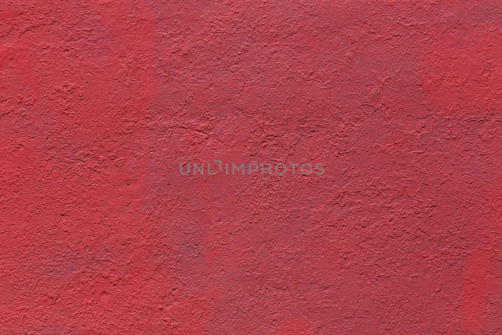 background and texture of flat thick painted matte red surface under direct sunlight - new paint over fragments of old peeled one