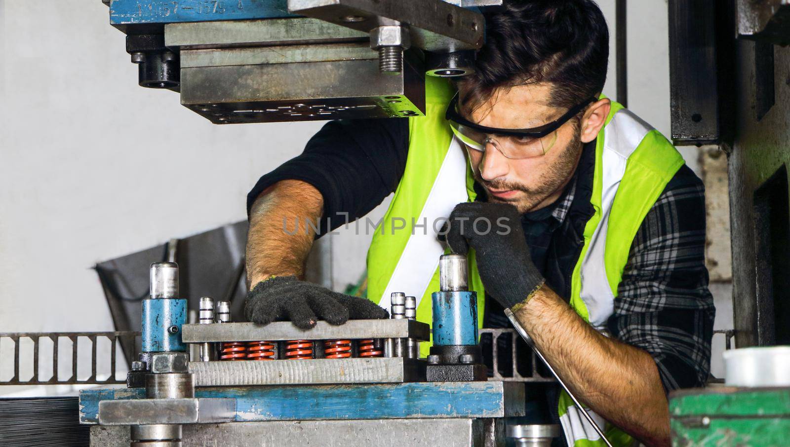 Portrait of a professional male engineer Wears safety uniforms and glasses. Maintenance and setup of machines In industrial factories producing metal parts with confidence Concept of engineering work