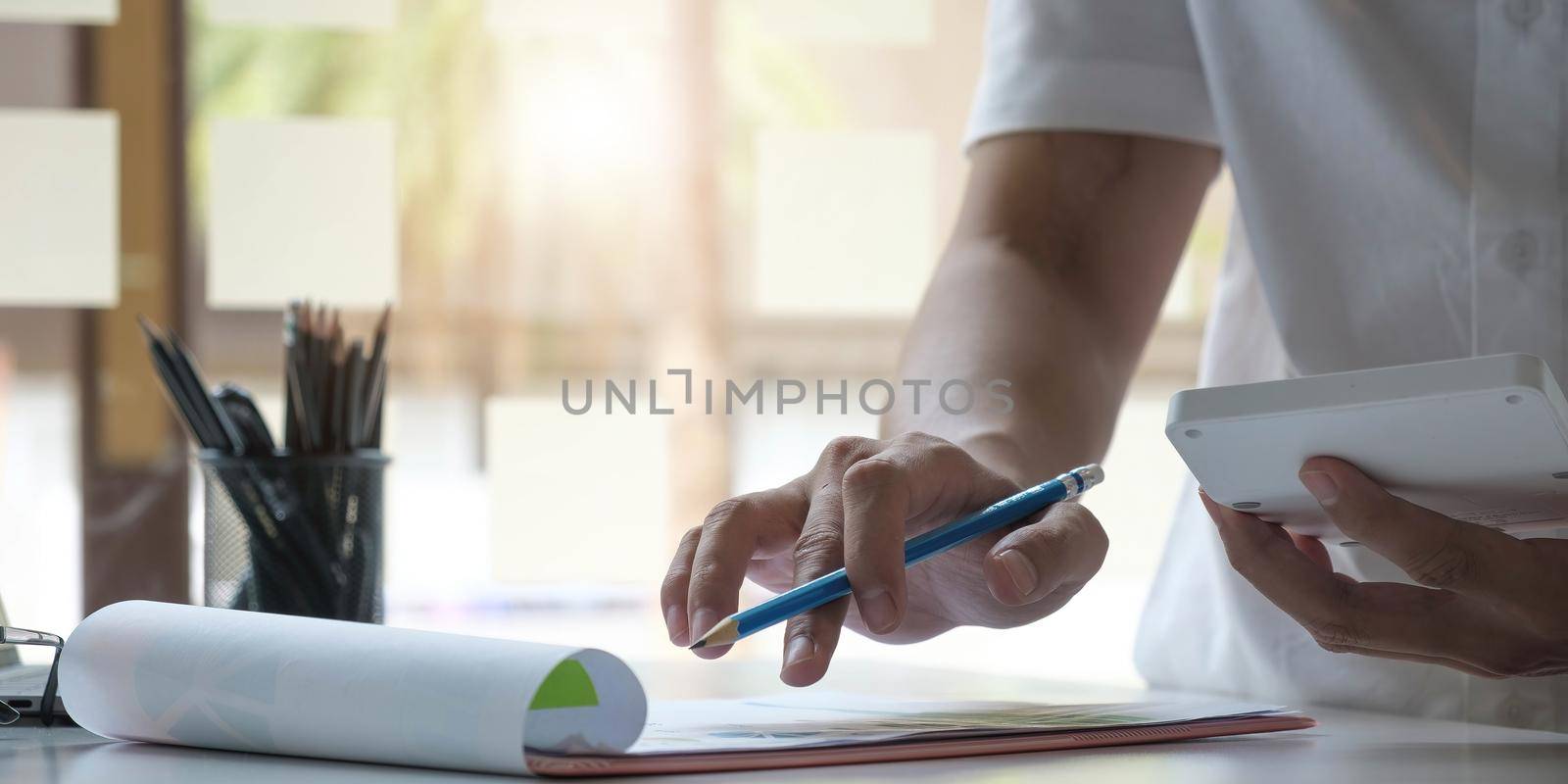 Business woman using calculator for do math finance on wooden desk in office and business working background, tax, accounting, statistics and analytic research concept.