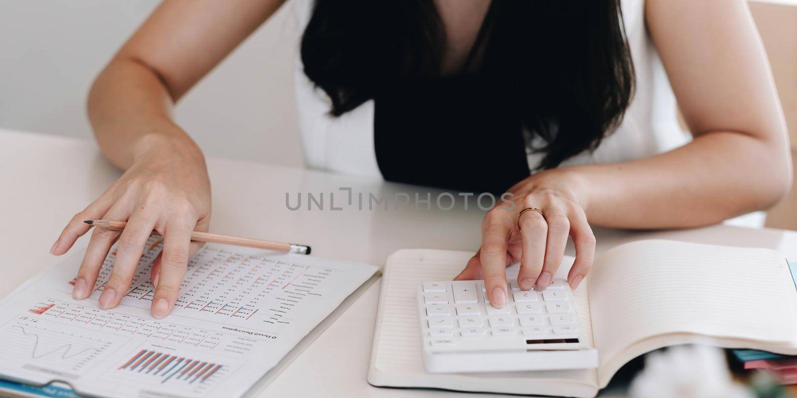 Close up Businessman using calculator and laptop for calaulating finance, tax, accounting, statistics and analytic research concept by wichayada