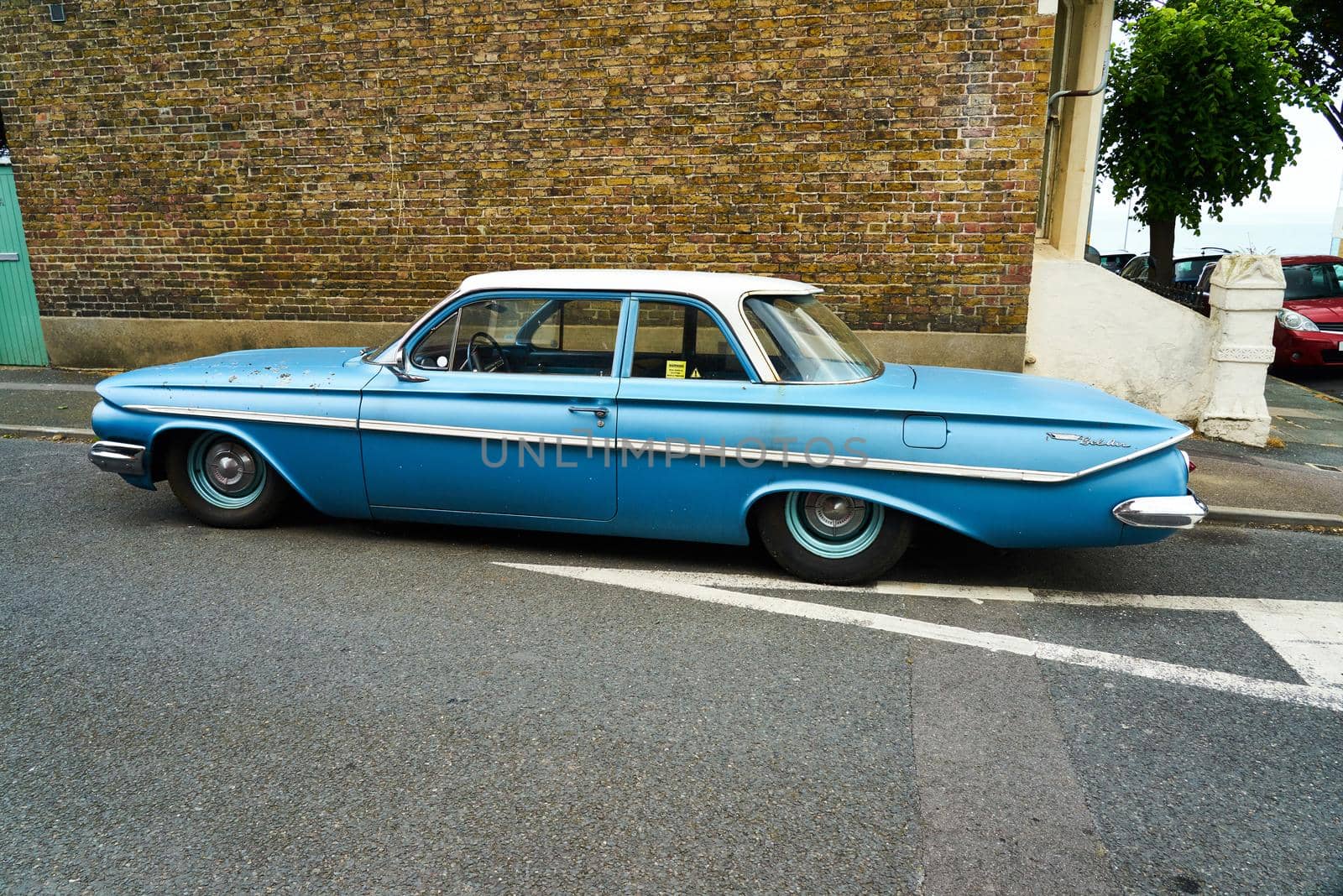 A blue 1961 4 door Chevrolet Bel Air sedan with chrome bumpers