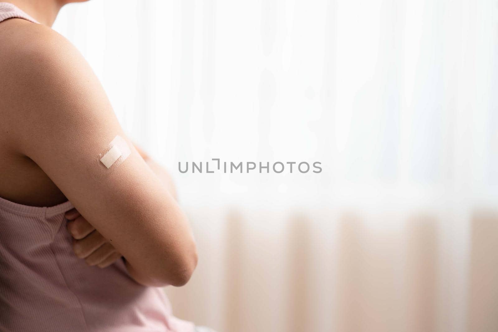 Man with bandage showing his arm after receiving vaccine. by sirawit99