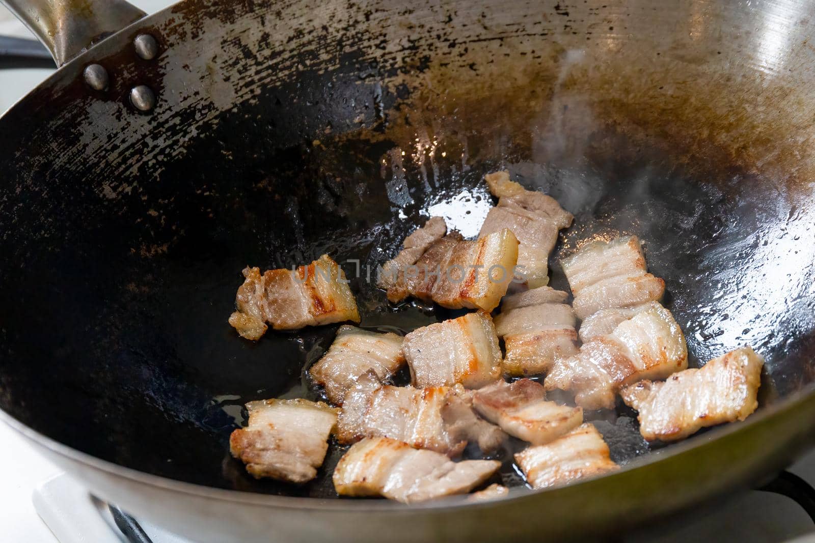 Sliced pork belly stir fried in a hot wok