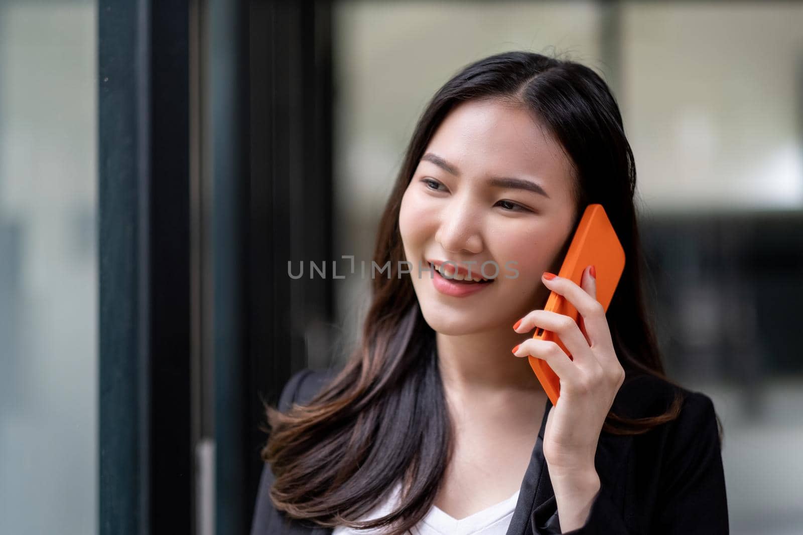 Close up asian business woman making a phone call and smiling at office.