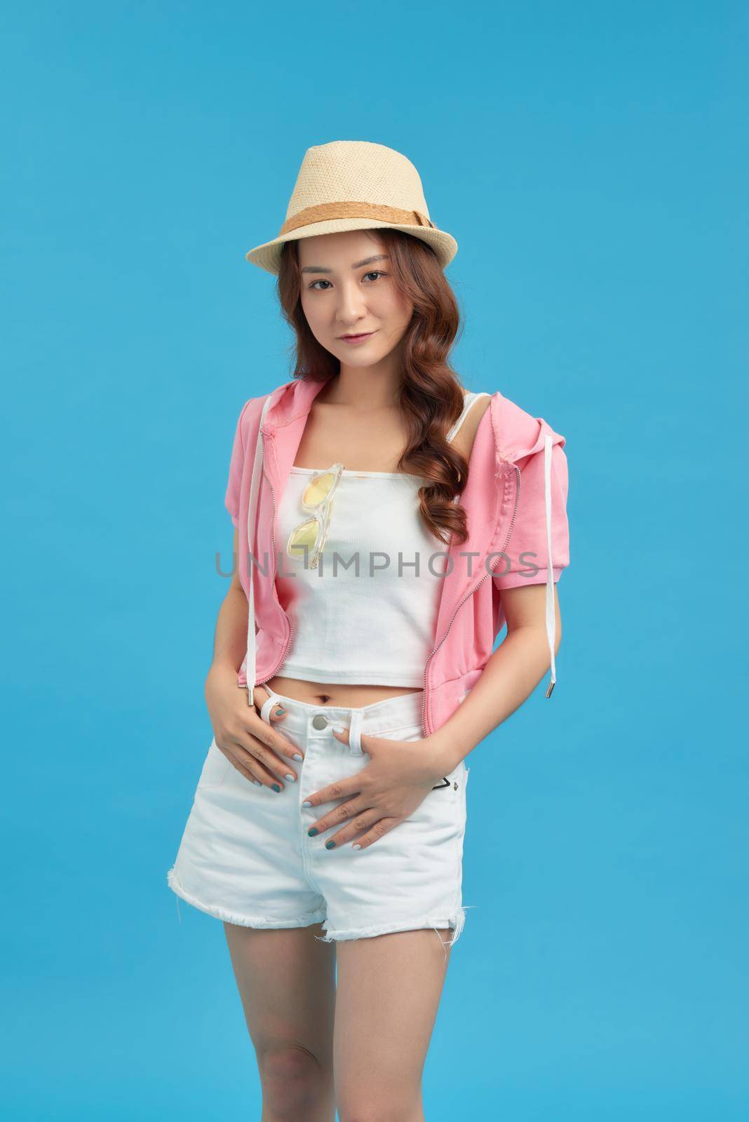 Sunny lifestyle fashion portrait of young woman wearing trendy outfit, straw hat