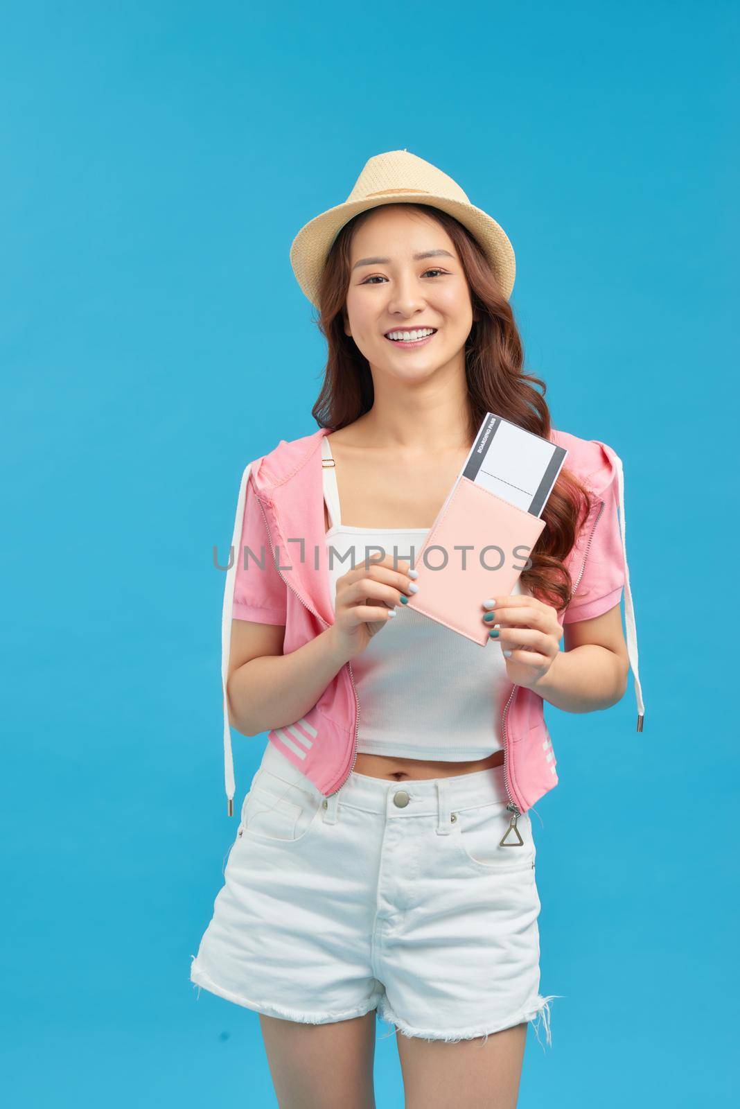 Portrait of young asian woman holding passport and smile. Happy people and travel concept.
