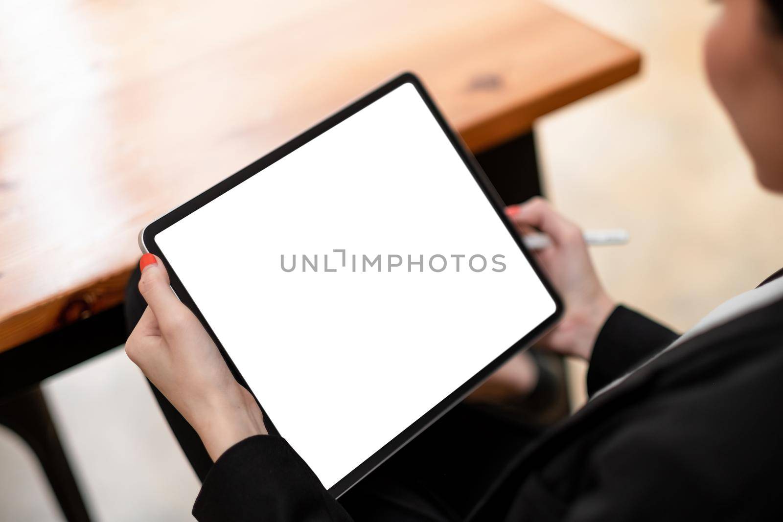 Close-up of woman working with stylus on digital tablet pc with blank white screen by nateemee