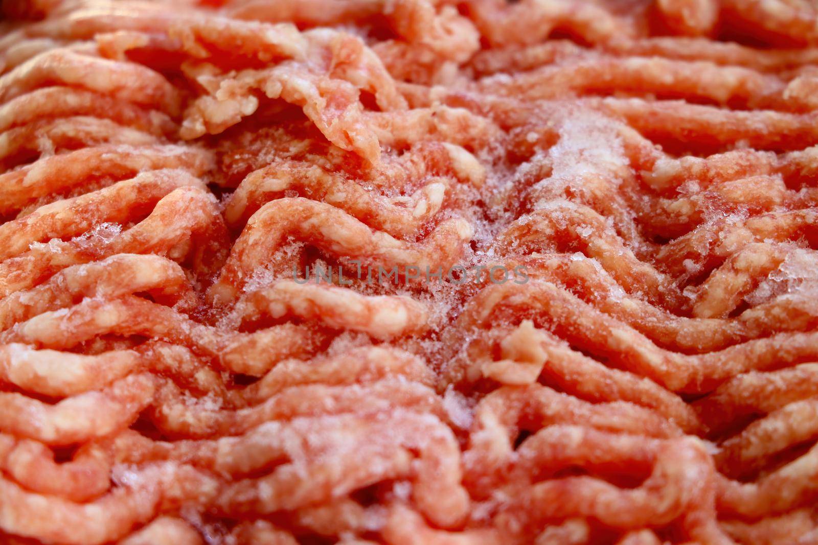 Close-up on red frozen minced meat. Background, texture of meat