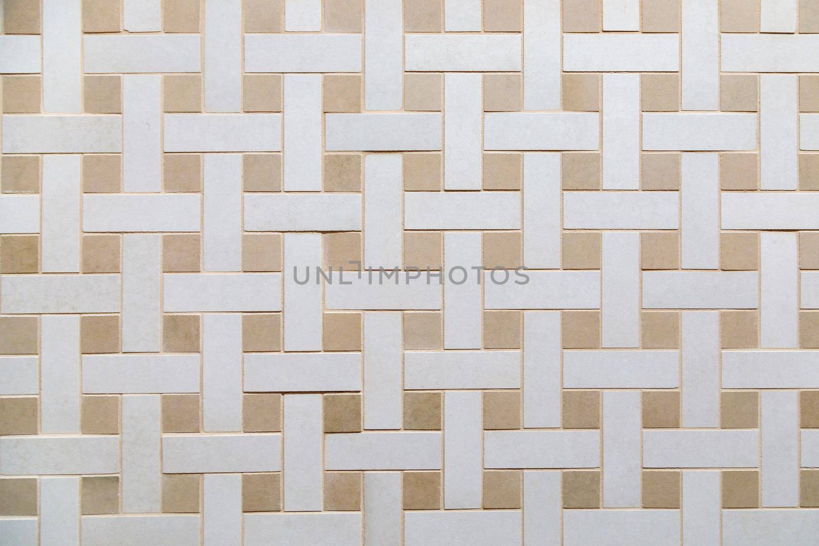 The texture of beige ceramic tiles with a weaving pattern. Construction material