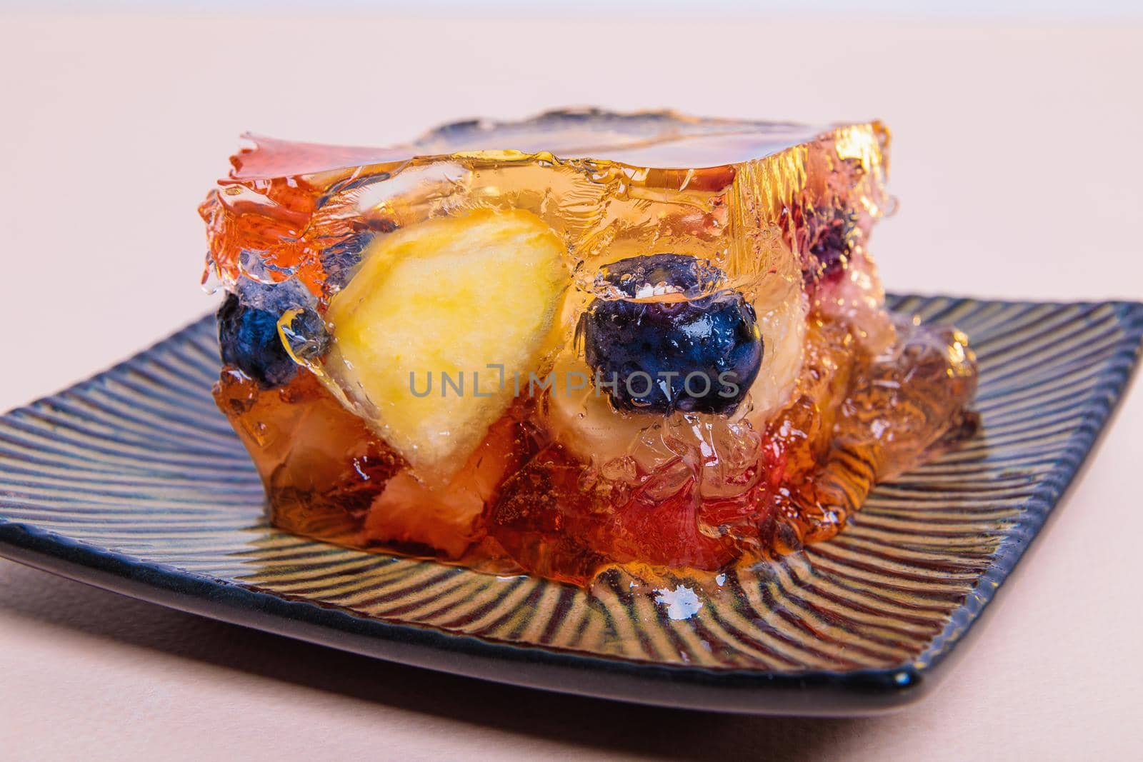 Jelly from different fruits and berries on a square saucer. Dessert. Close-up