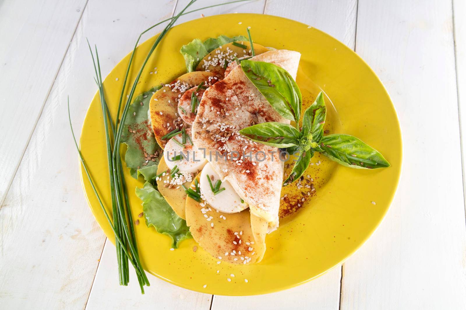 Vegan cuisine presentation of a flatbread based on entirely vegetable foods prepared on a mustard-colored plate 