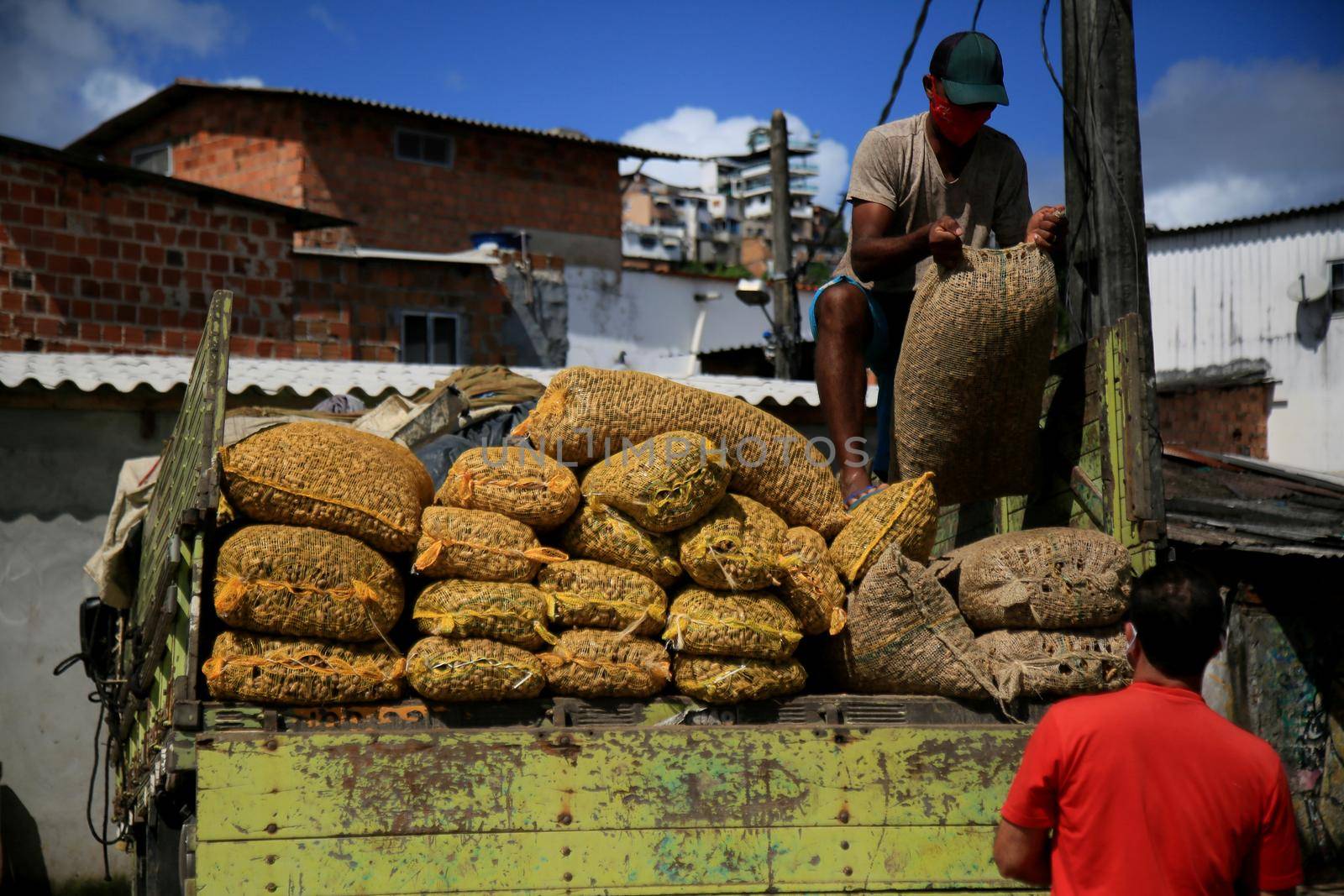 salvador, bahia, brazil - june 28, 2021:People are seen unloading bags of peanuts from a truck at the Sao Joaquim fair in the city of Salvador.

