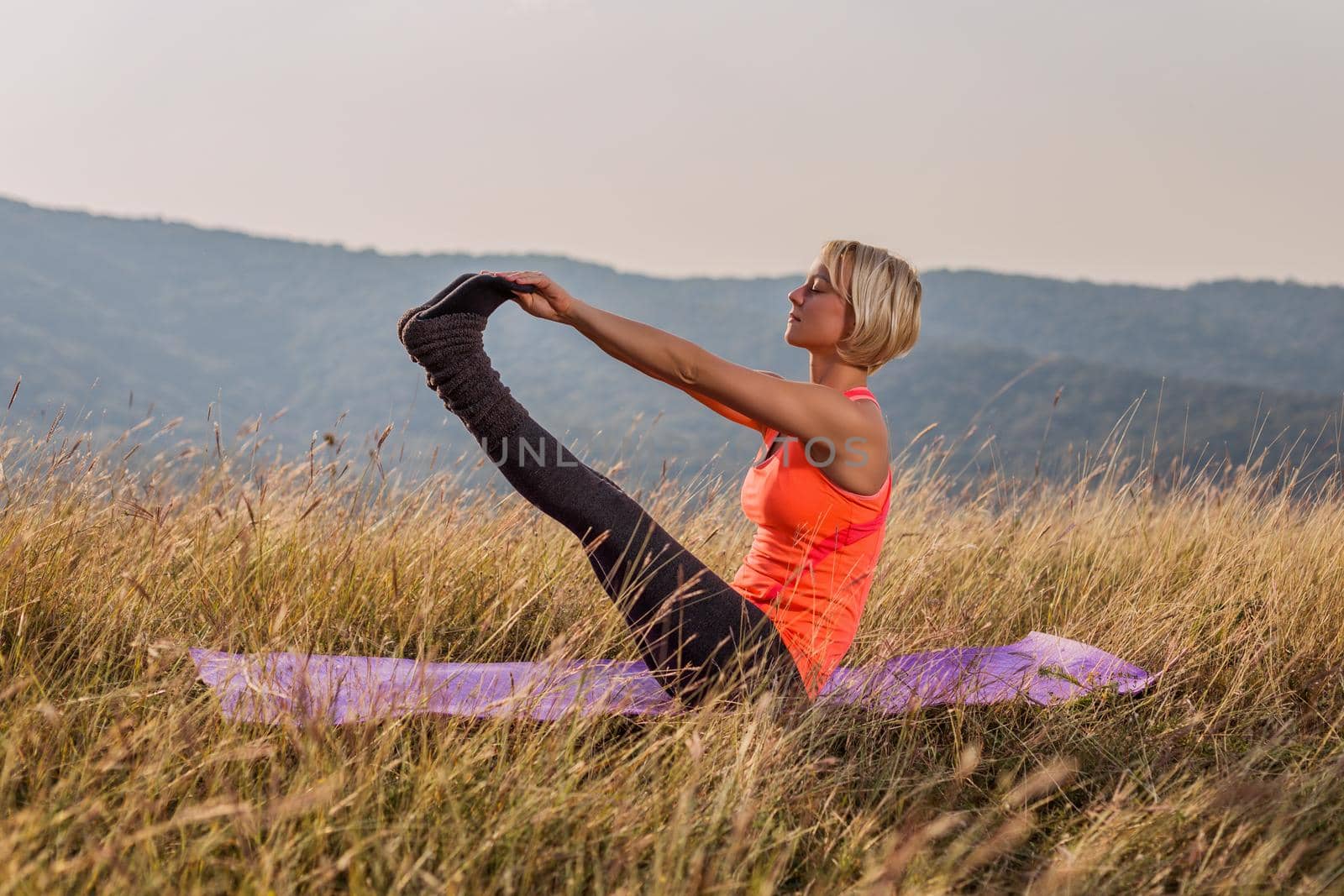 Beautiful woman doing yoga in the nature,Navasana/Boat Pose.Image is intentionally toned.