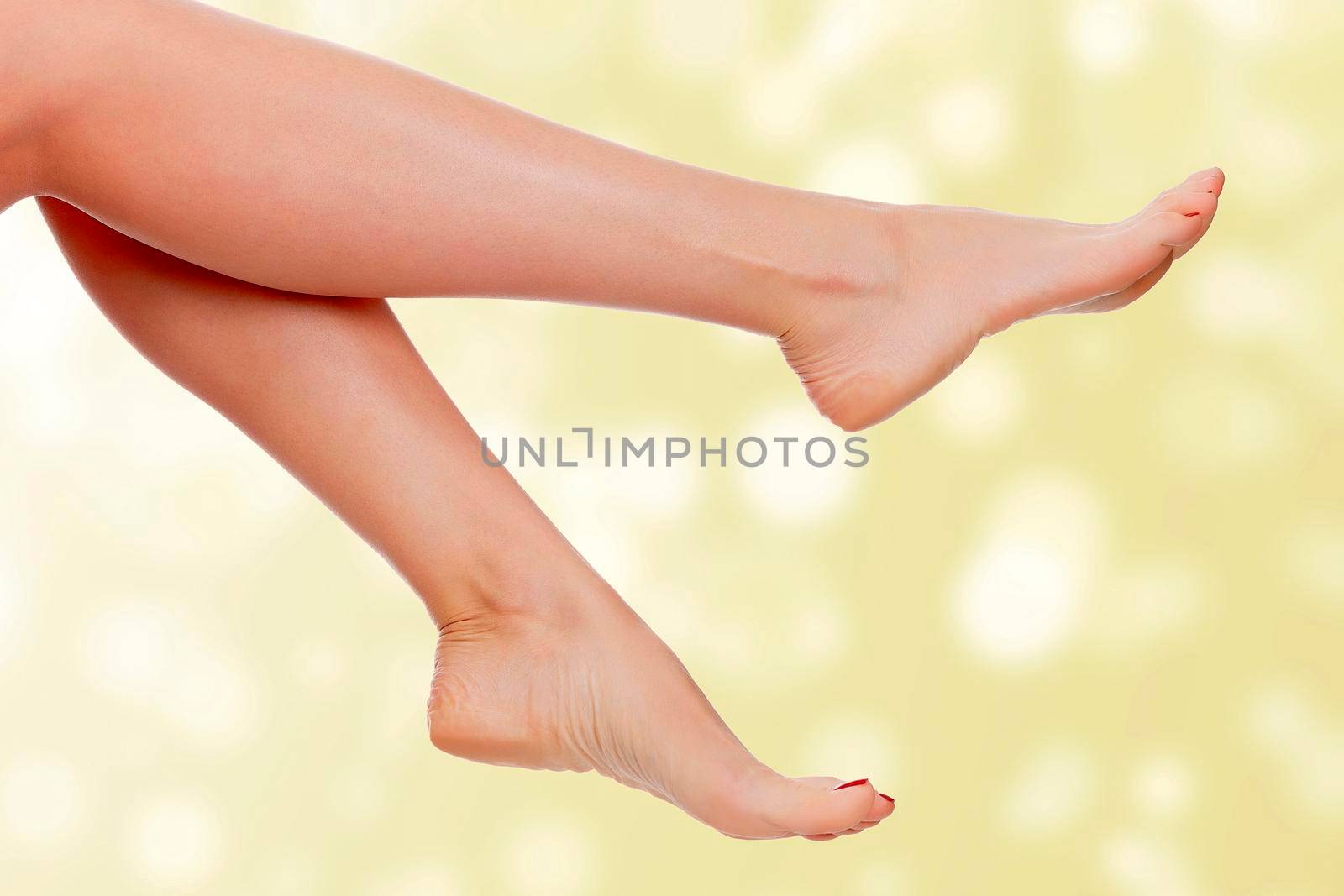 Long female legs on an abstract background. Skin care concept by Nobilior