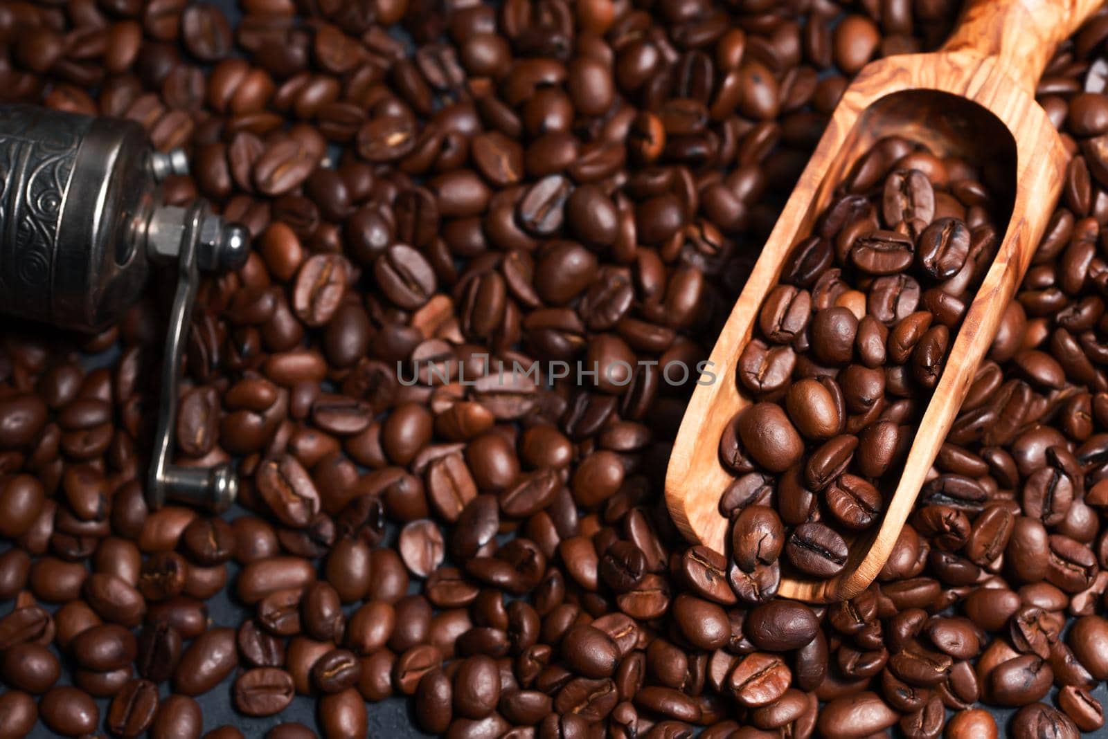 Fresh brown roasted coffee beans flat background with measuring scoop and coffee grinder