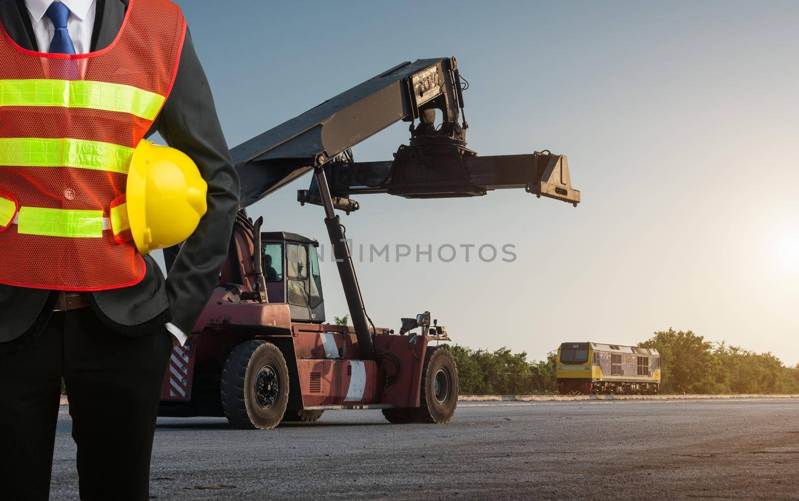 Businessman stand on front forklift loading Containers box by Sorapop