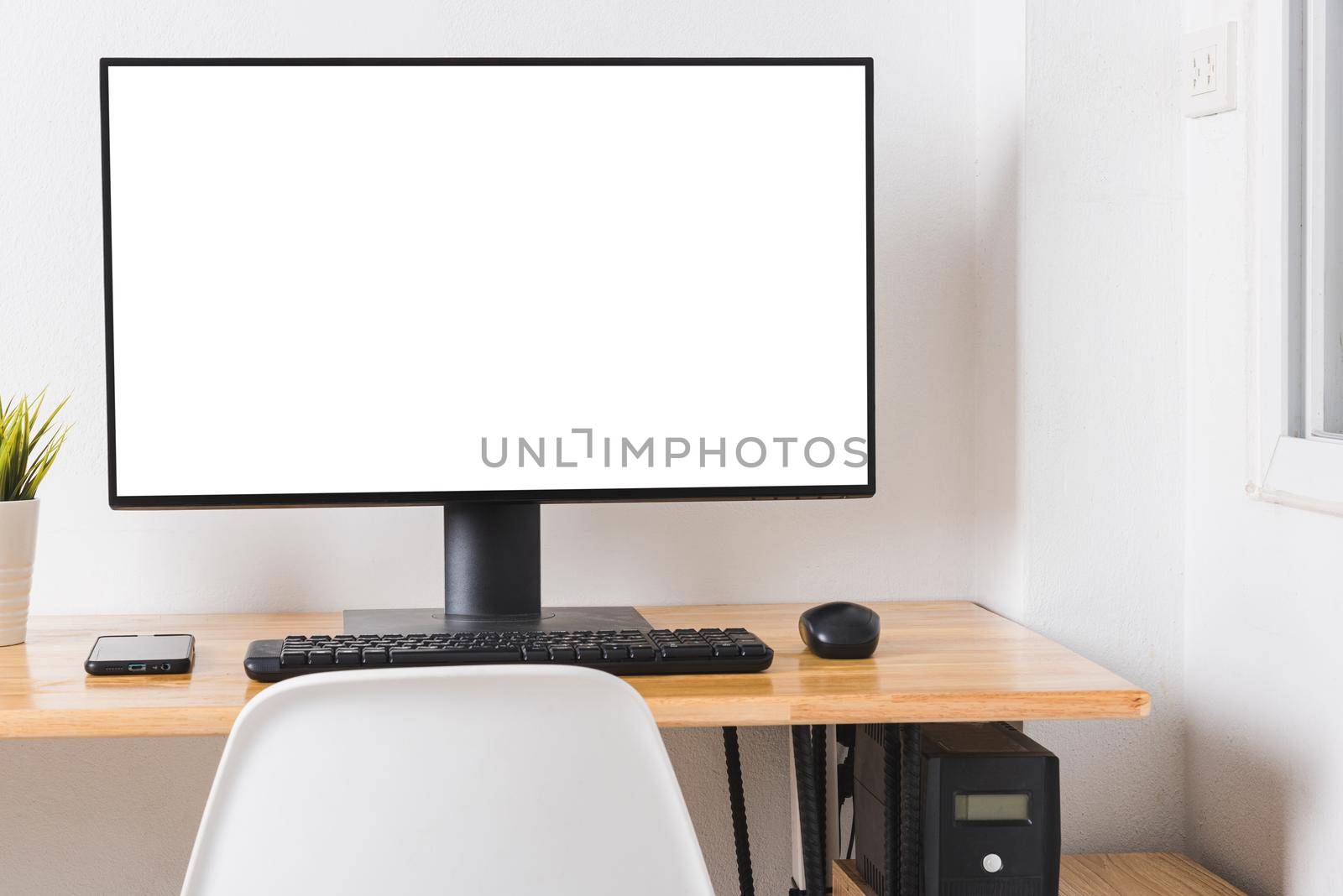 Computer monitor with white blank screen on the business desk with wireless mouse, keyboard at home office over white wall background, Photo of equipment contemporary workspace