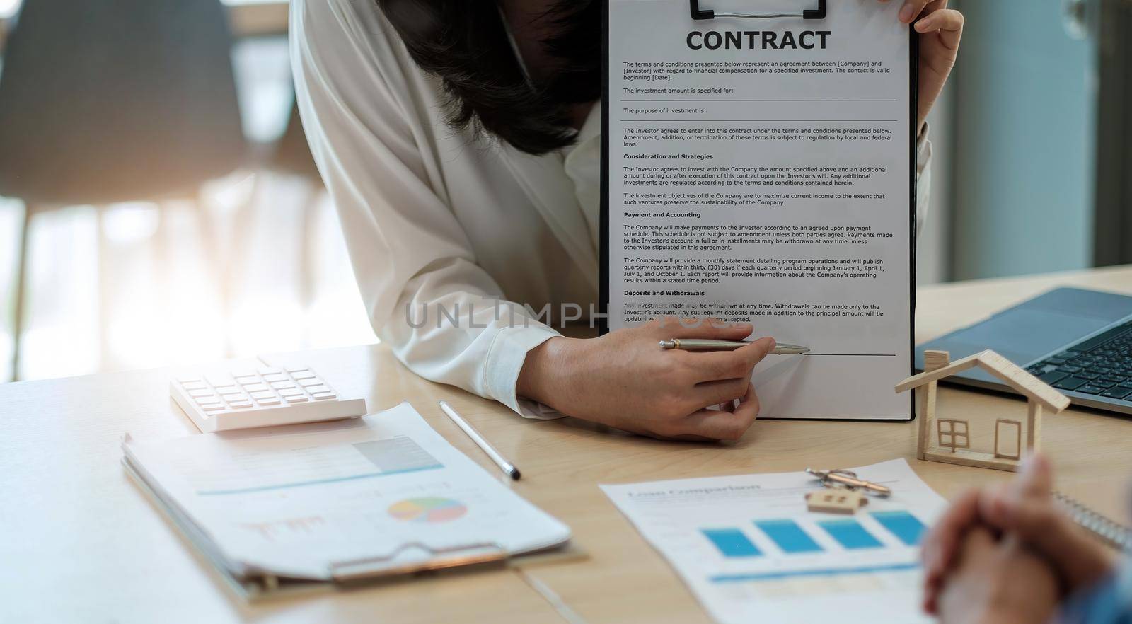 Sale purchase contract to buy a house, Real estate agent are presenting home loan and giving keys to customer after signing contract to buy house with approved property application form.