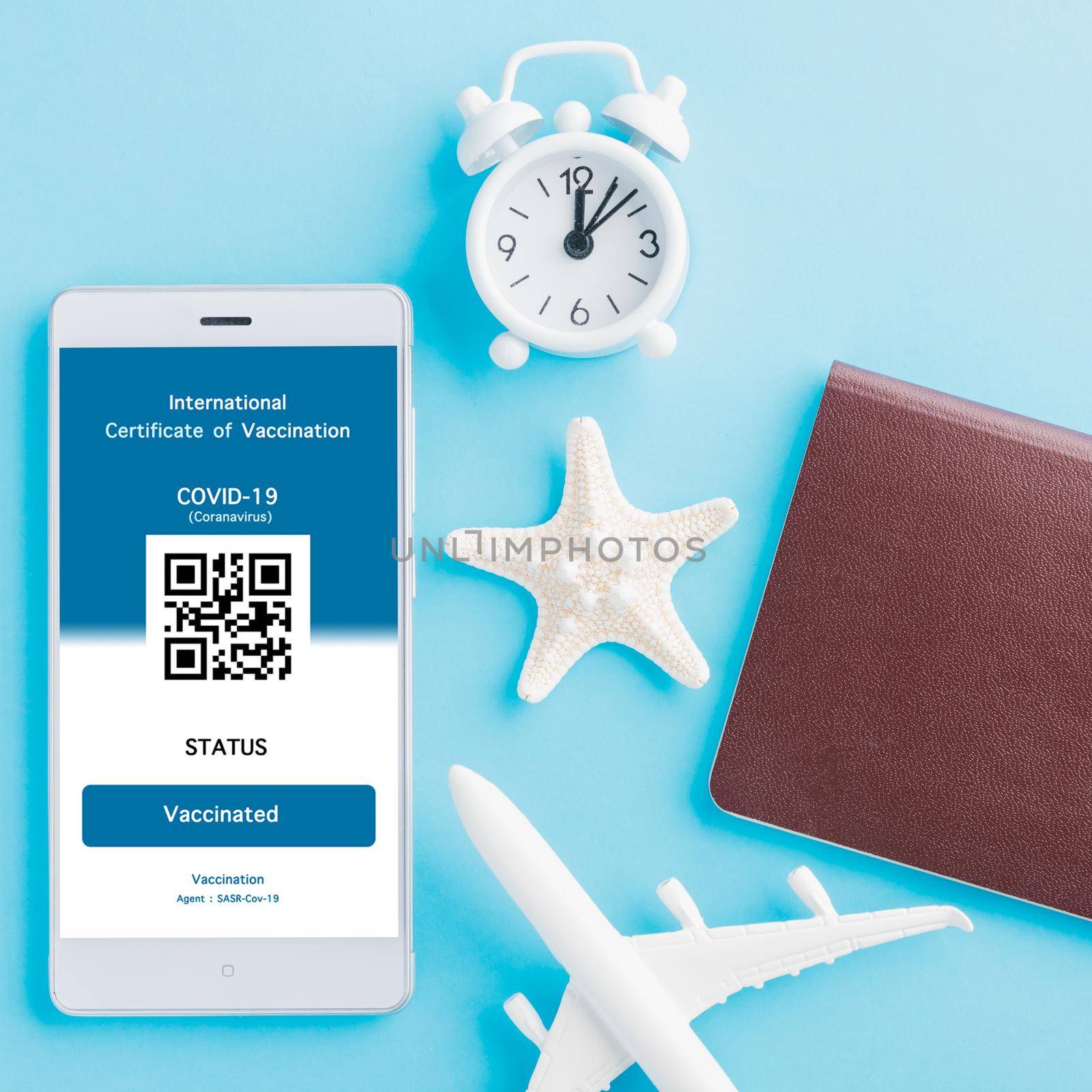 Model airplane, passport and immunity pass are arranged application on smartphone on blue background, Travel concept during Covid-19 pandemic digital International Vaccination Certification concept