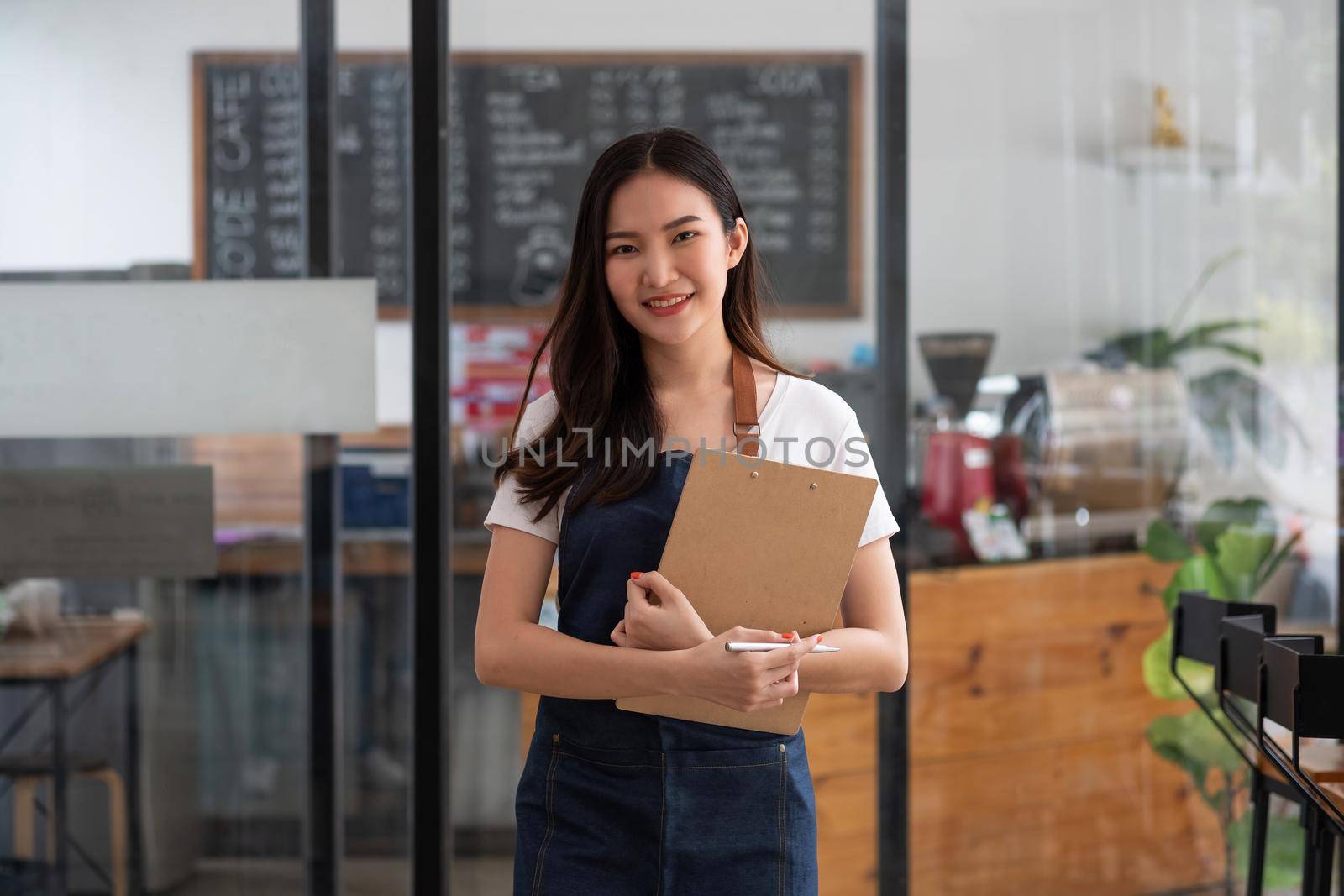 Startup successful small business owner woman beauty girl standing in coffee shop restaurant. Portrait of smiling asian woman barista cafe local owner.