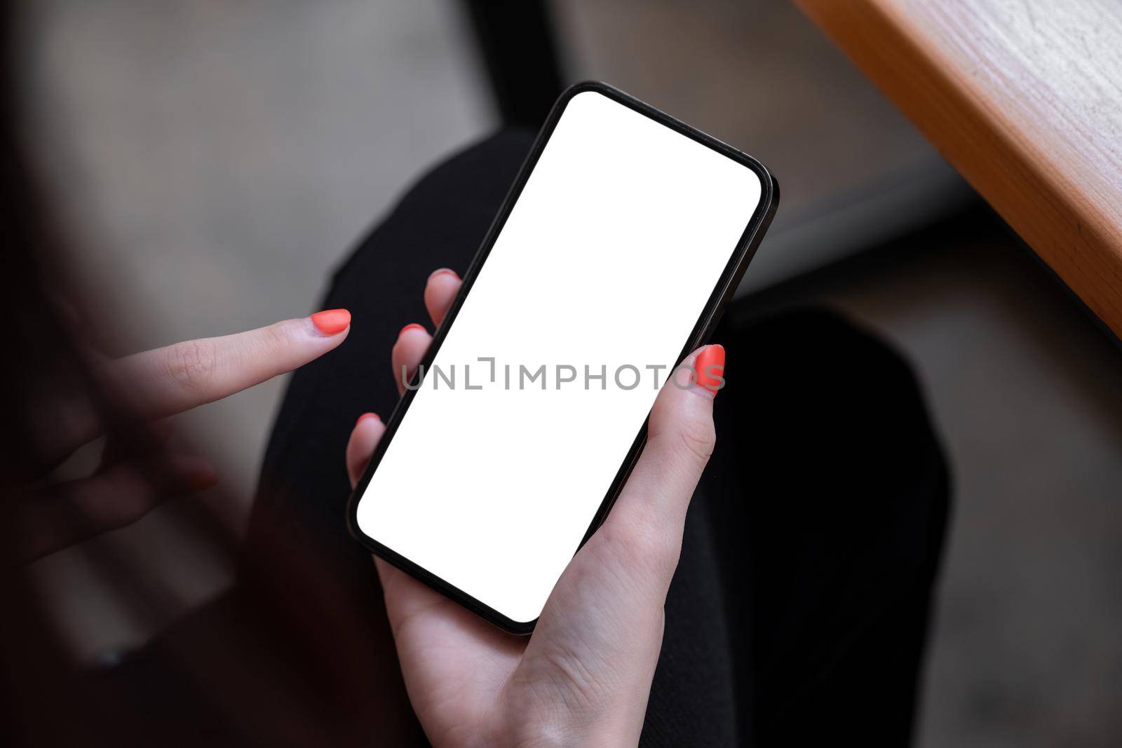 Top view mockup image of a woman holding black mobile phone with blank white screen while sitting in cafe. by nateemee