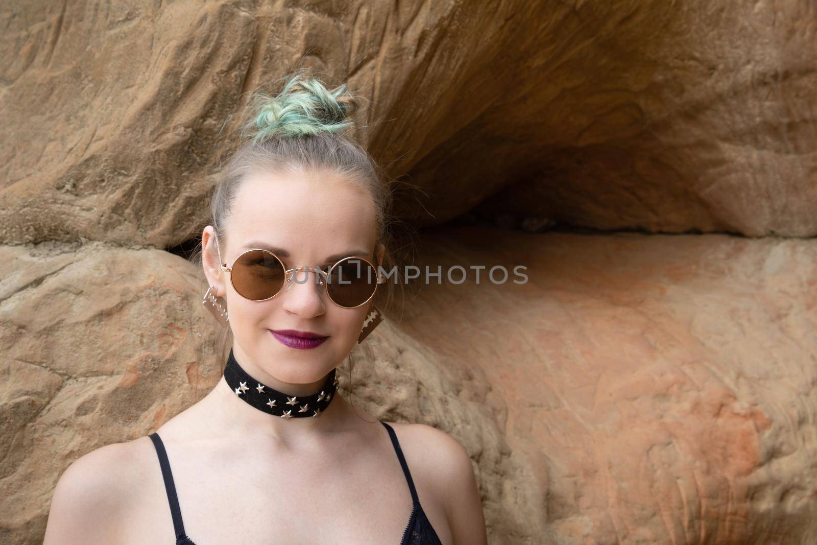 Beauty and healthy lifestyle. Young woman in black lingerie posing near the sandstone caves on the seashore. Shell rock caves.