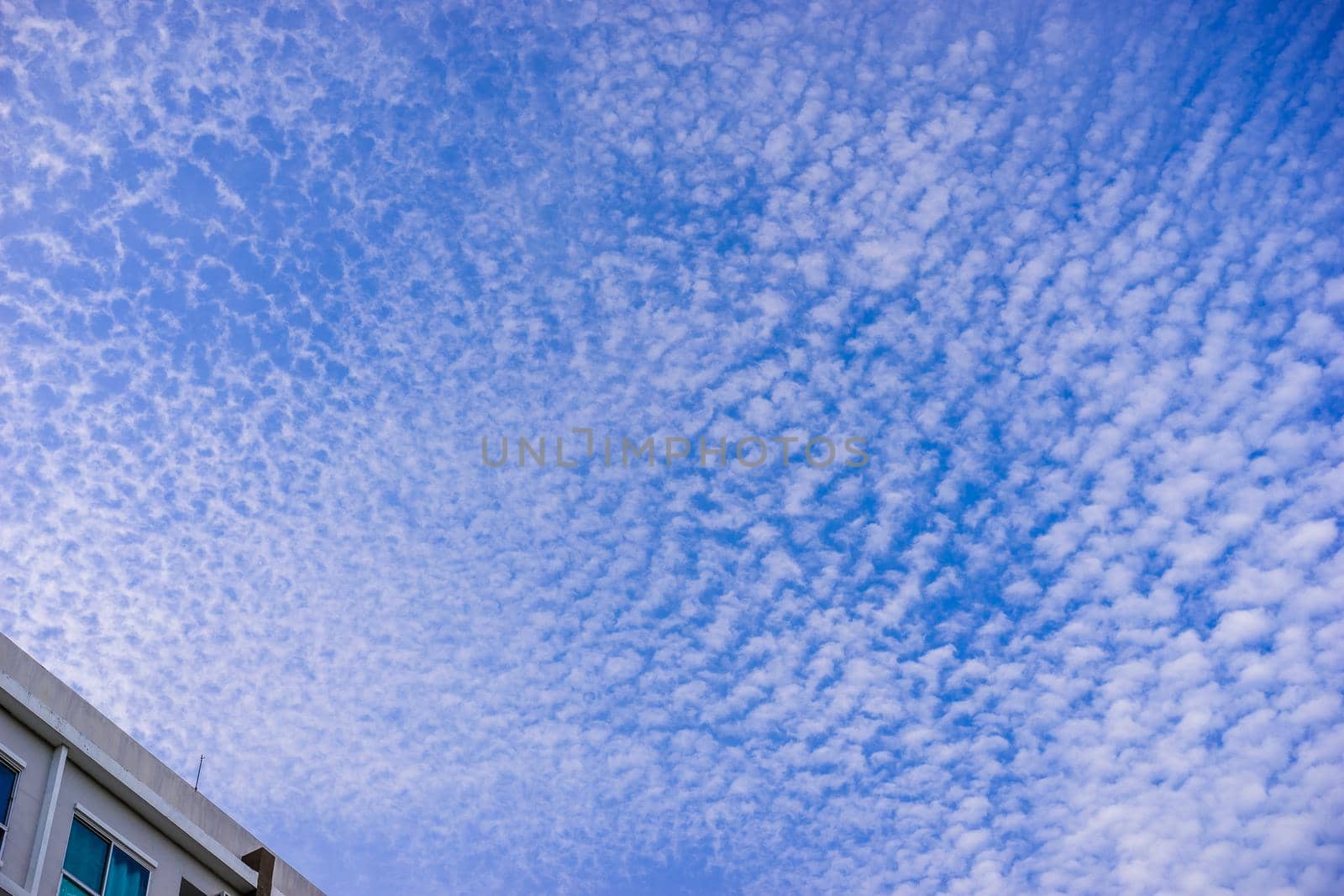 Blue sky background with clouds and building in the morning