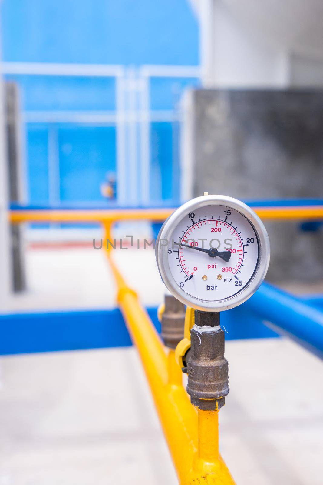 Closeup of manometer for measuring gas pressure. Pipes and valves at industrial plant.